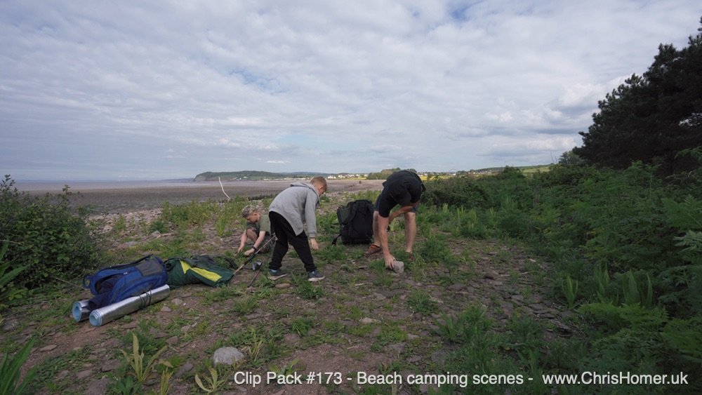 The Journey: Backpacking sequences walking through the countryside, rural farmland scenes, and along the beach to the chosen camp spot.