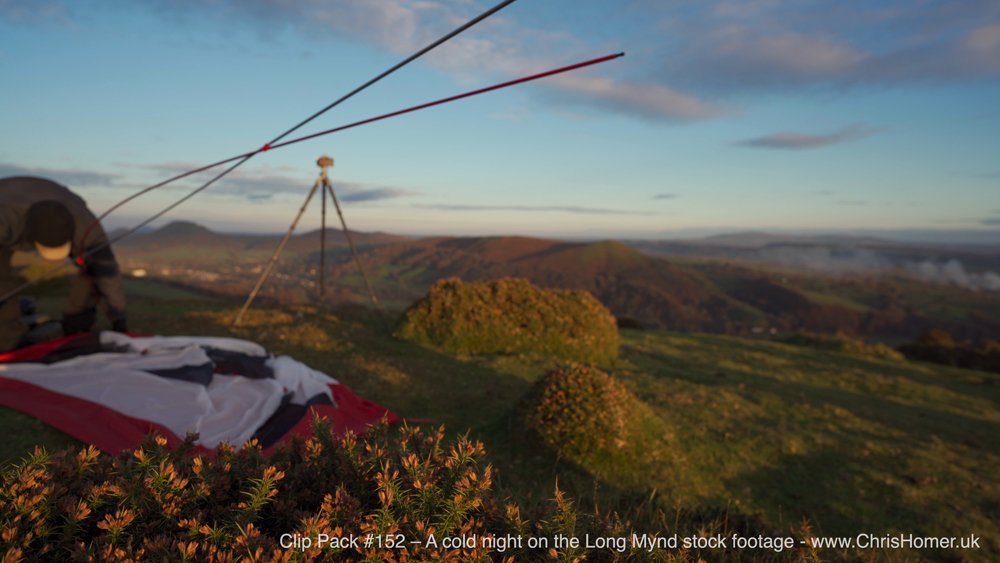 Setting up a wild camping tent in idyllic countryside