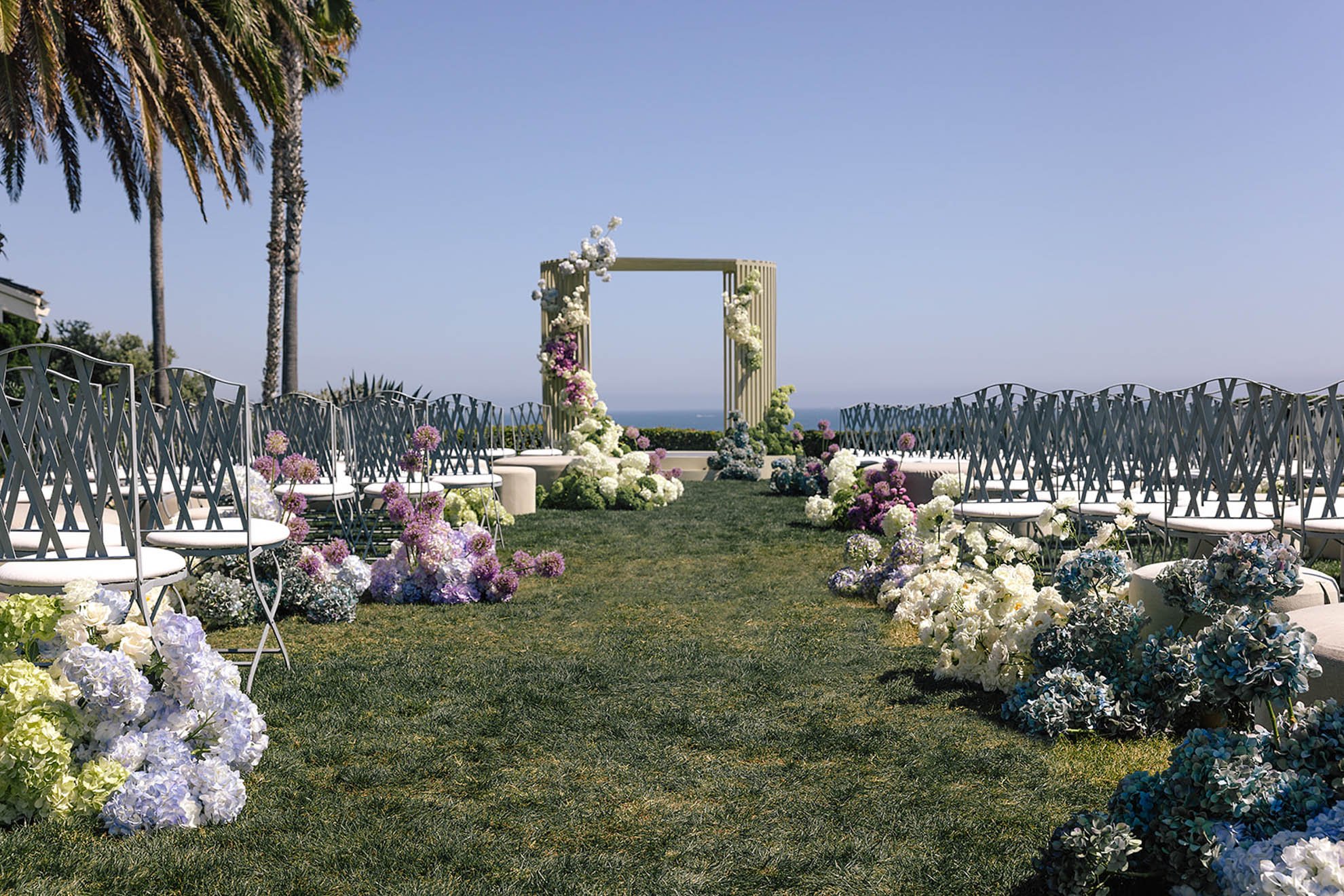 California destination wedding ceremony with colorful floral aisle and modern clustered floral altar design