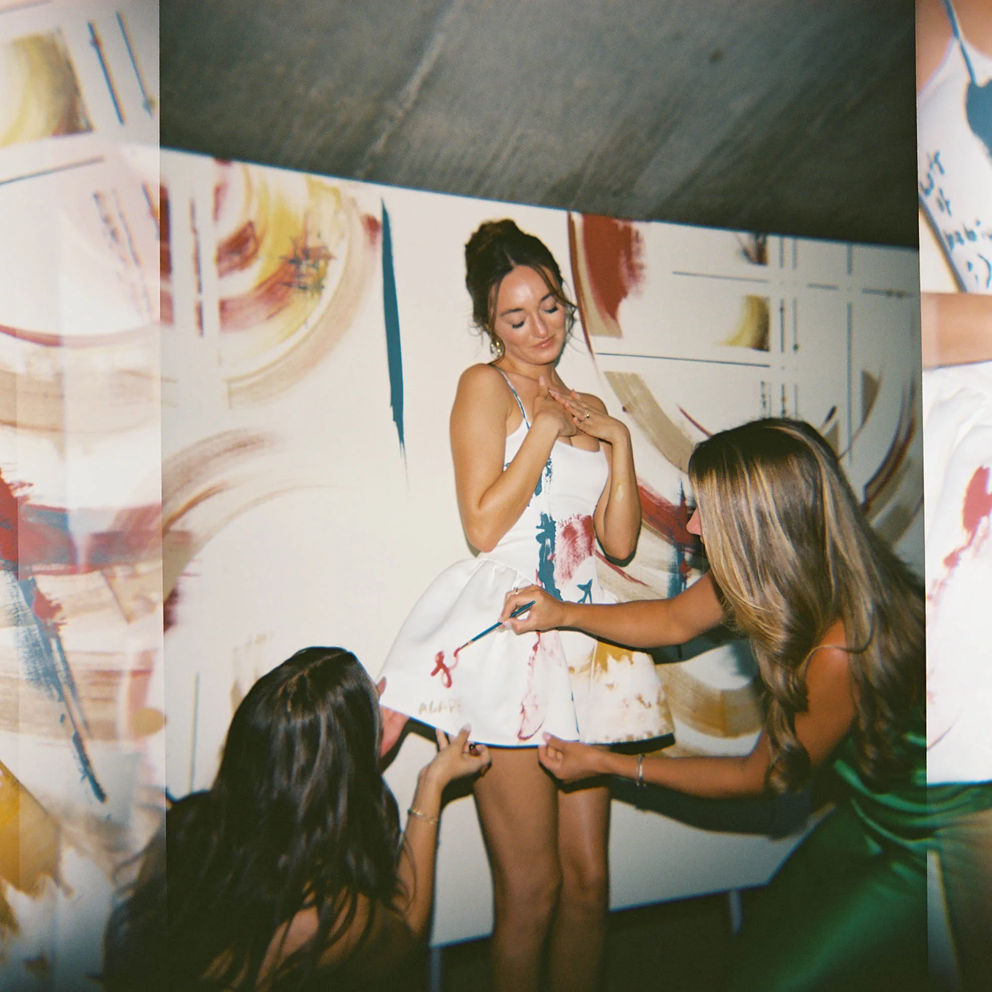 Bride’s wedding dress being painted on during the celebration as an interactive guest experience, designed by Mandy Marie Events.