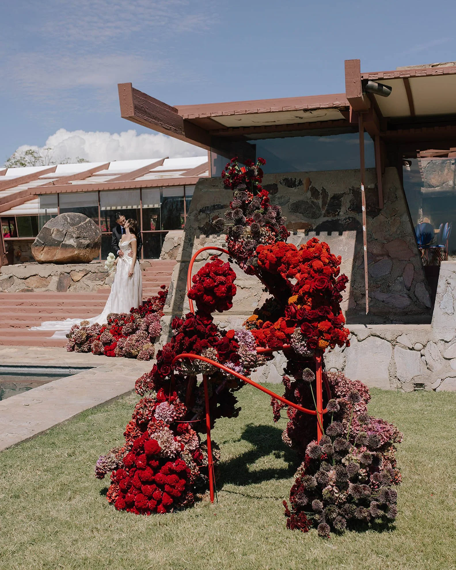Bride in a J. Andreatta wedding gown at an outdoor ceremony at Taliesin West, a Frank Lloyd Wright property, showcasing a modern and architectural wedding setting