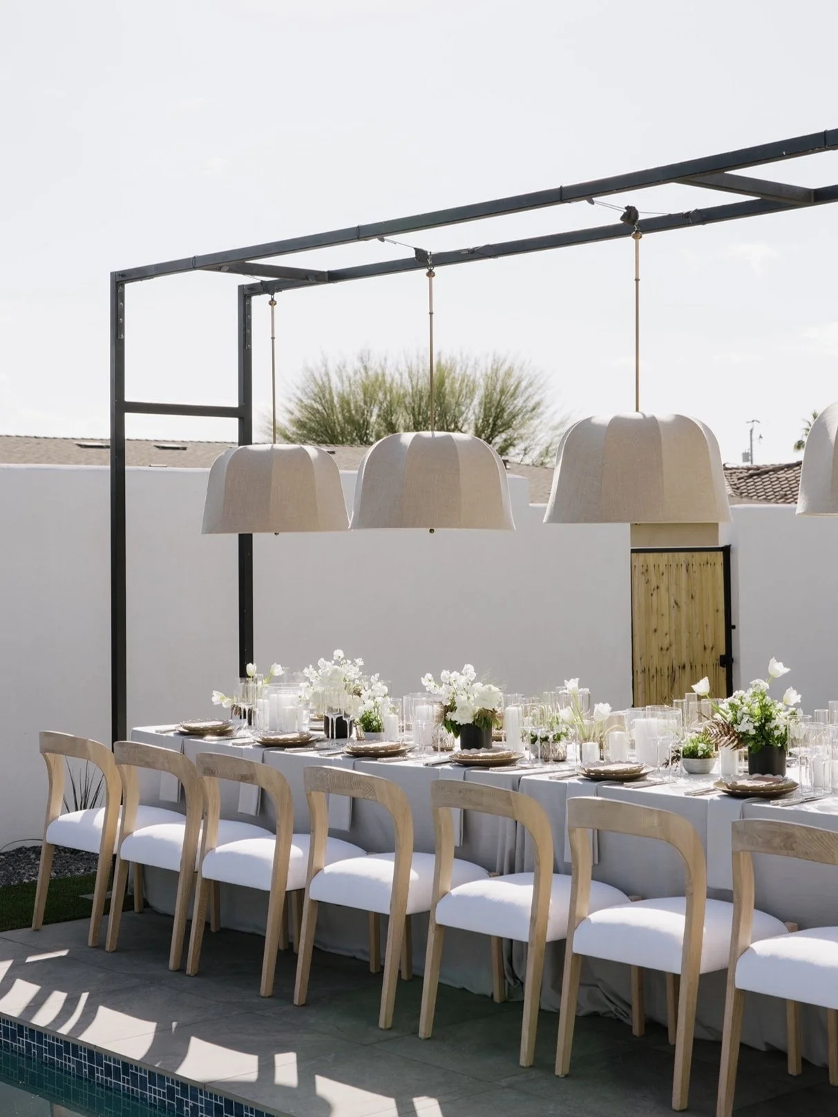 Minimalist dinner reception with pendant lighting and white floral centerpieces at Scottsdale private estate.