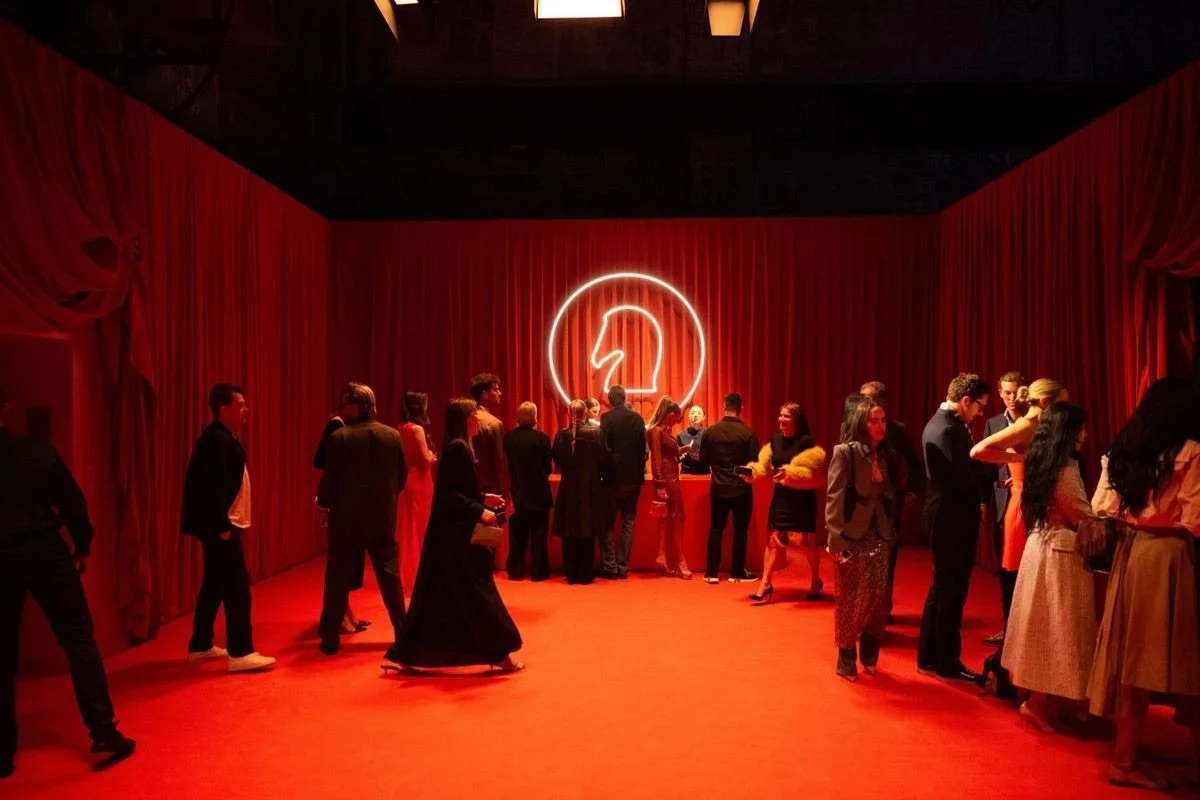 Hermes corporate event in red room with neon horse outline logo