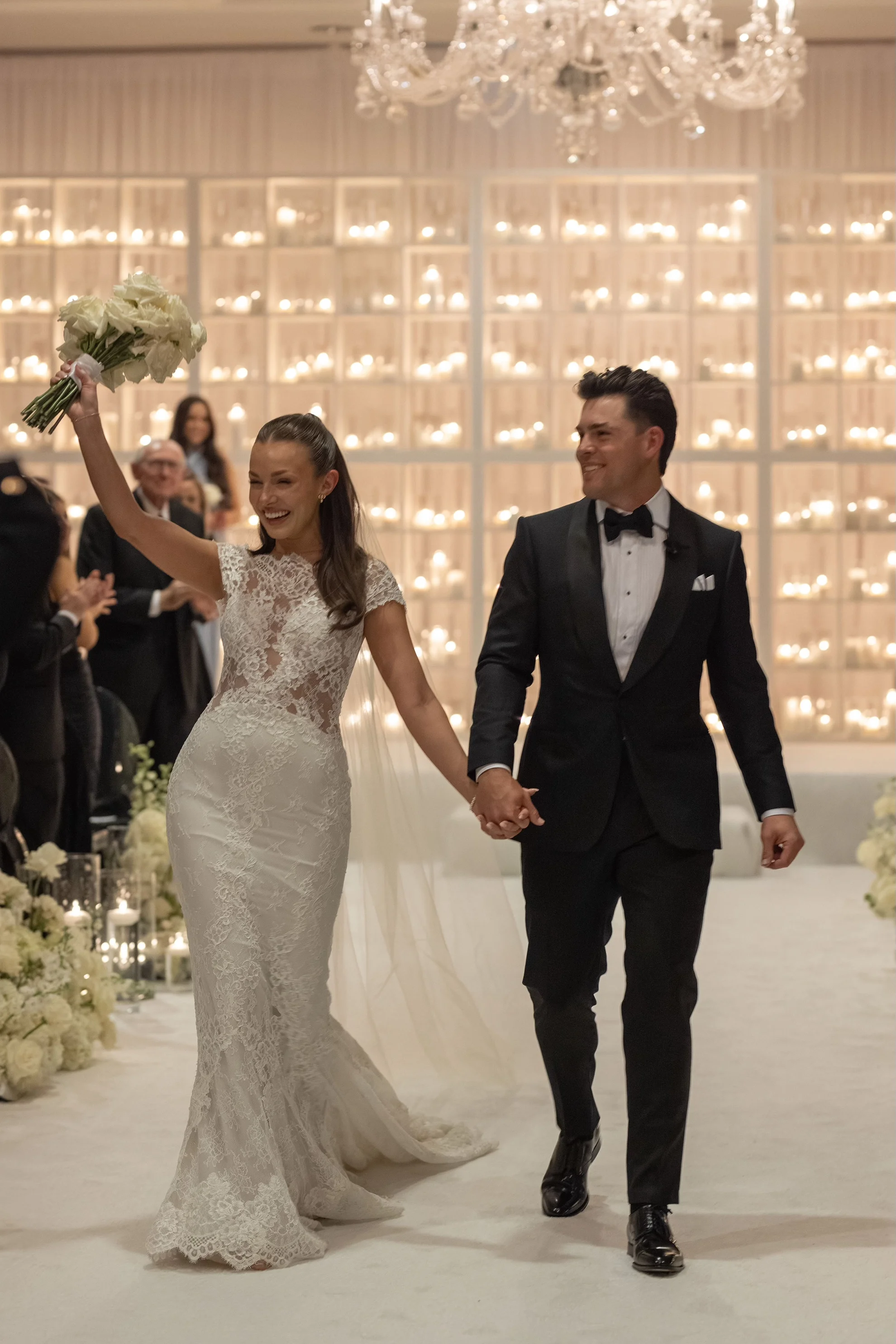 Bride in an Ines Di Santo wedding gown walking in recessional with groom in Tom Ford, showcasing modern wedding fashion that reflects a multi-day celebration style
