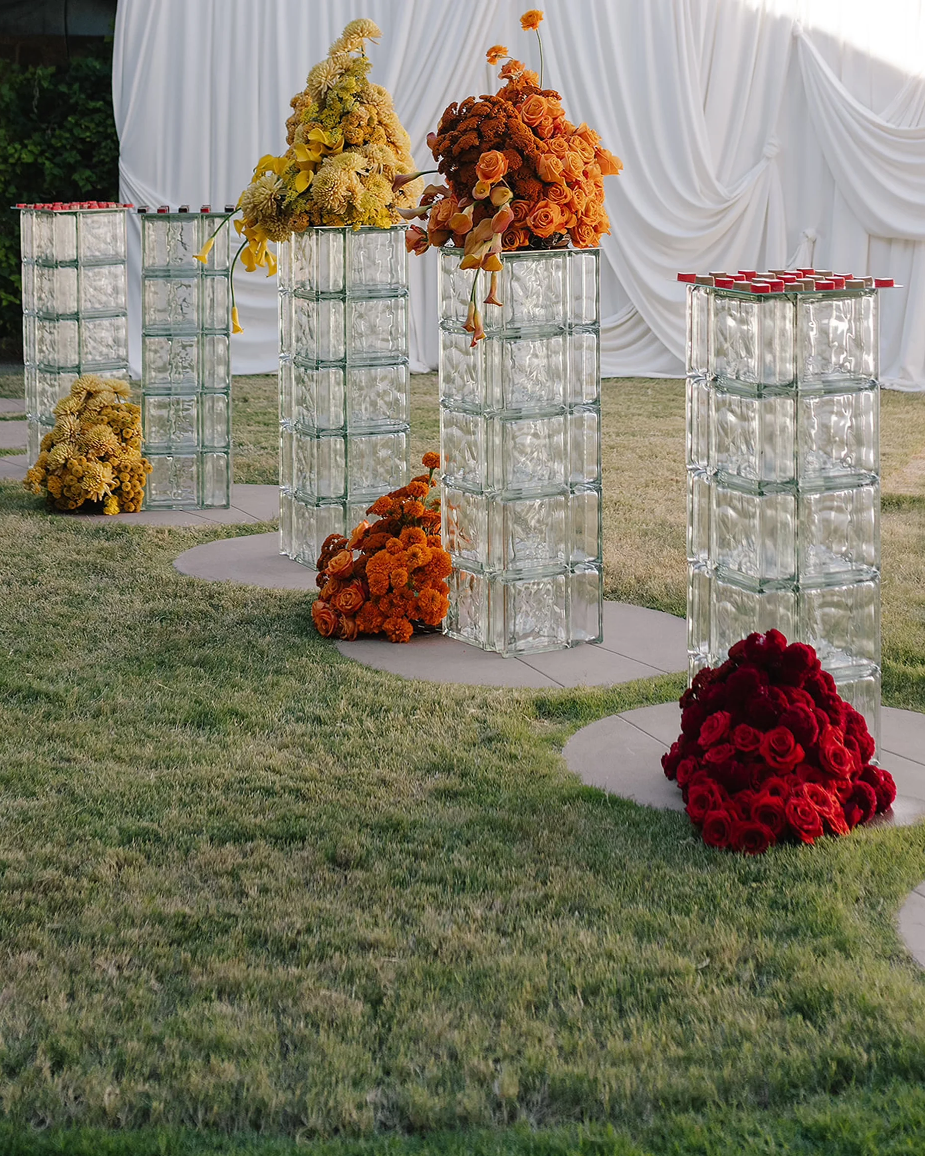 Glass block pedestals with color-blocked structural florals, creating a sculptural wedding installation with clean lines and intentional negative space