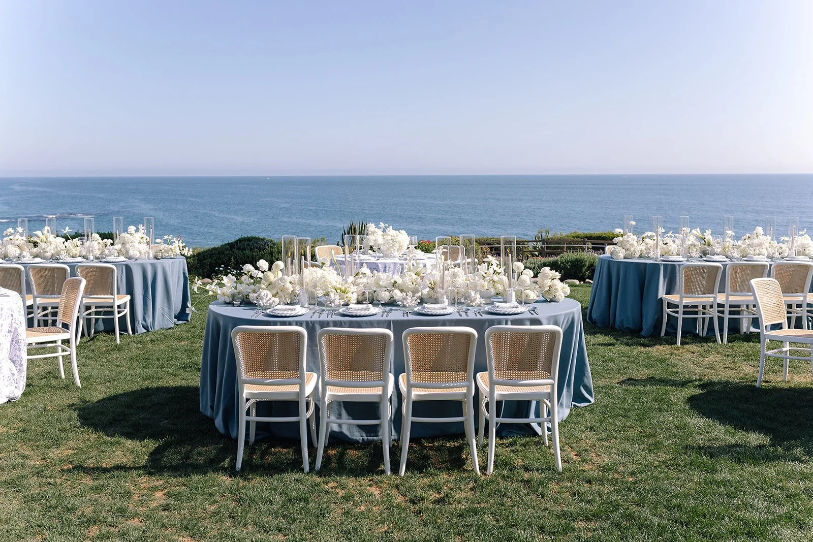 “Outdoor wedding welcome party at Montage Laguna Beach with neutral décor, blue accents, and ocean views from the lawn.”