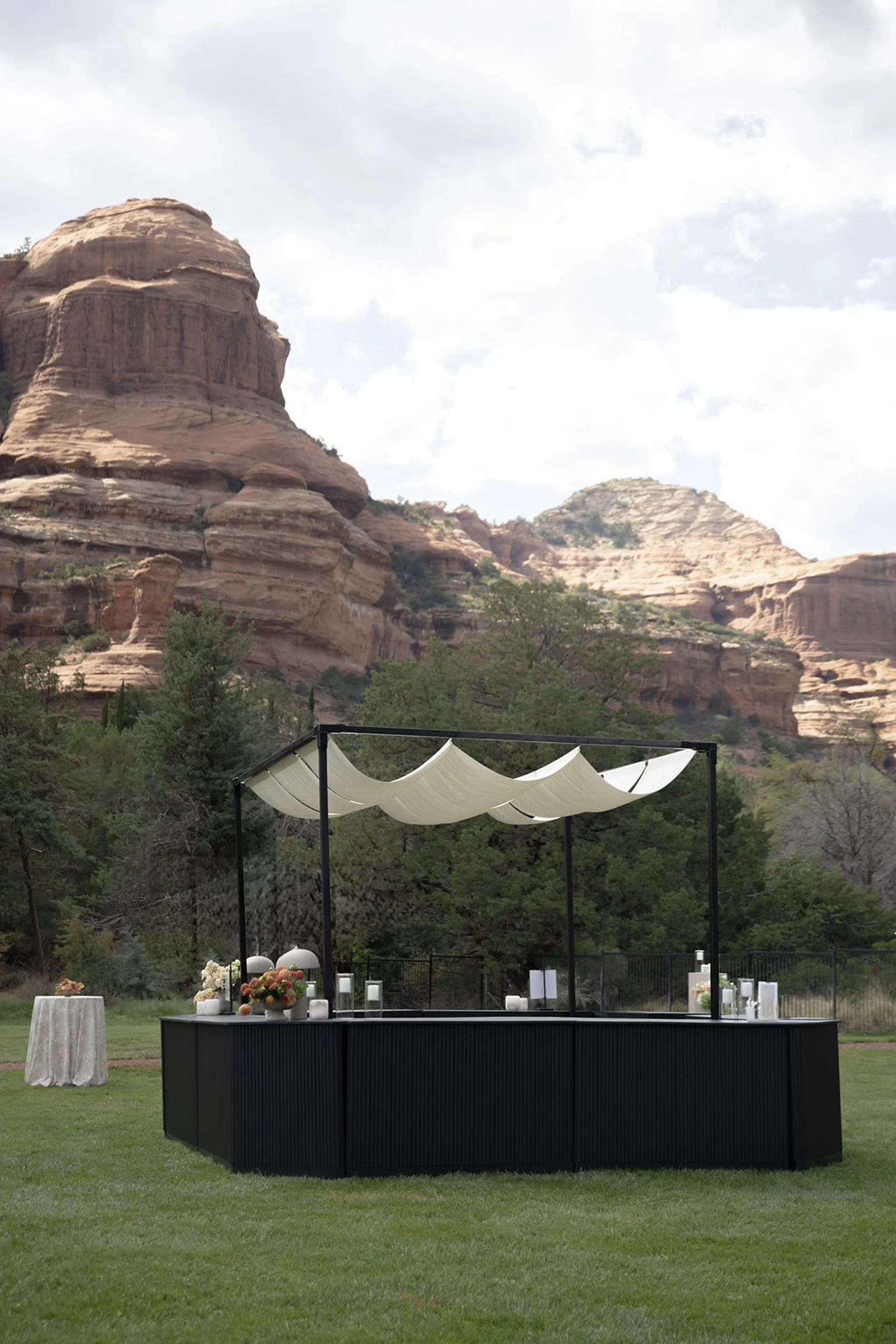 Outdoor wedding cocktail hour in an open field surrounded by Sedona's red rock landscape at Enchantment Resort.