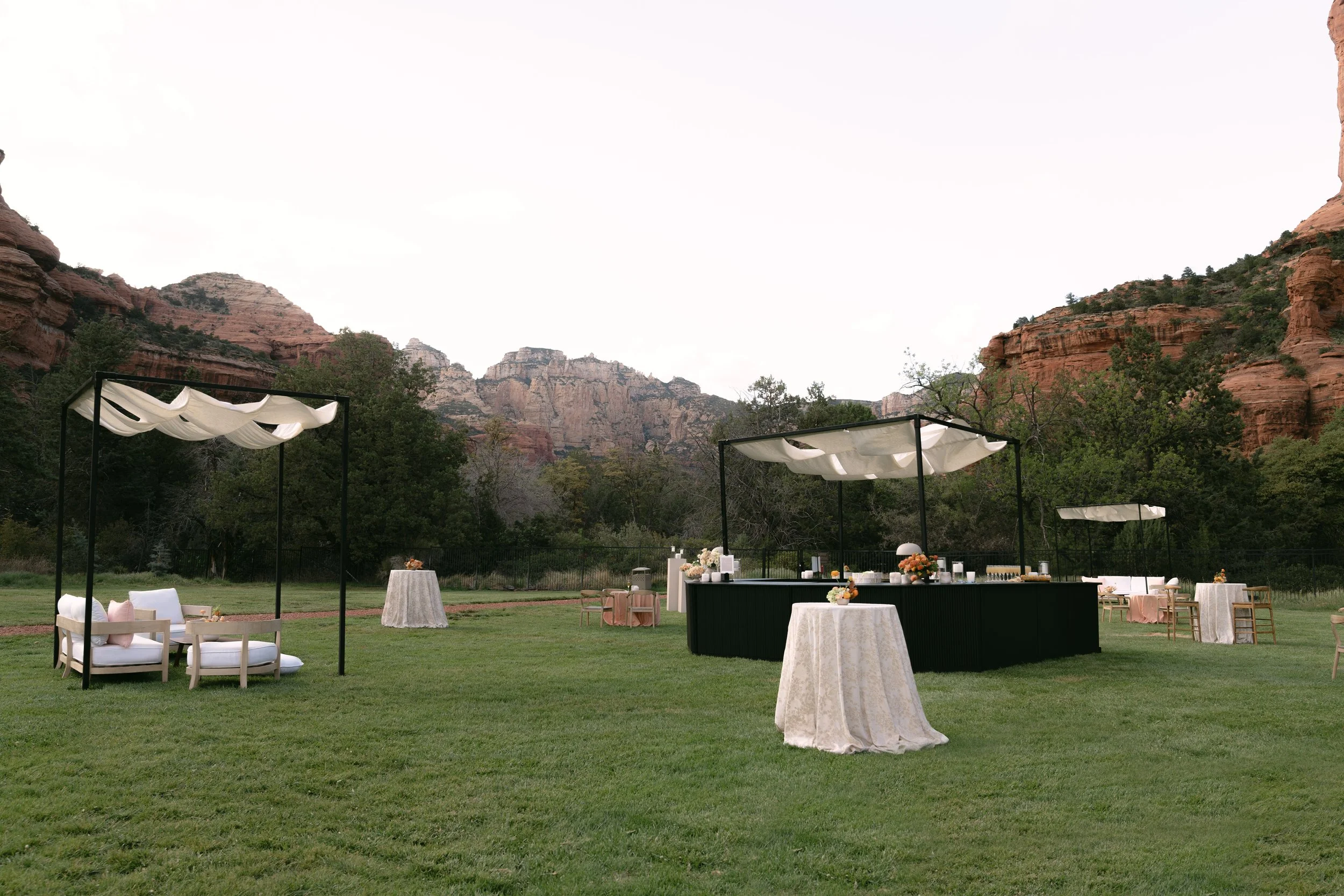 “Outdoor cocktail hour at Enchantment Resort in Sedona, Arizona, with custom canvas canopies draped over the bars and seating areas.”