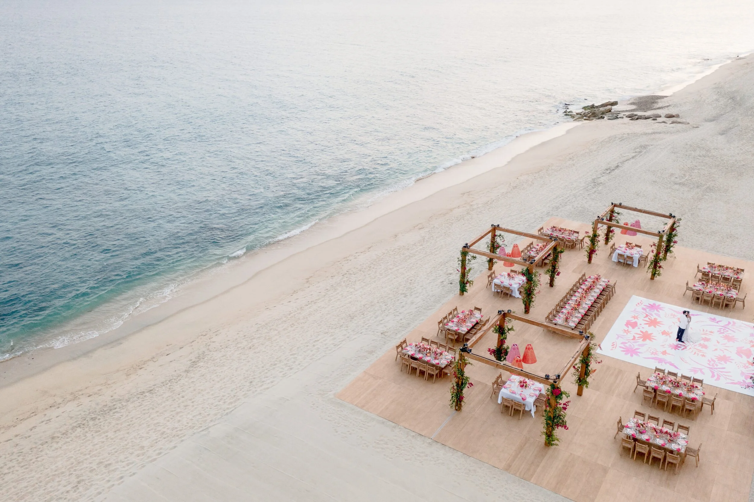Beachfront wedding at Zadún with bold fascia, wood flooring, custom lighting, and dance floor decal.
