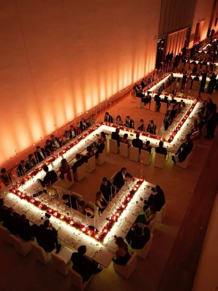 Corporate dinner with LED-lit centerpieces and zigzag tables in modern setting