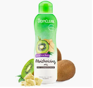 Green Tropiclean moisturizing leave-in conditioner bottle with kiwi, ginger, and coconut ingredients arranged in front.