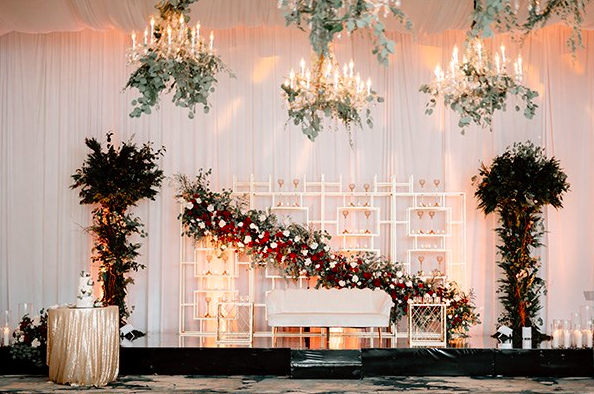 Spacious hotel lobby with modern decor, a yellow curved sofa, decorative statues, and a staircase leading to an upper level.