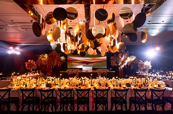 Beachside resort with white and navy umbrellas, palm trees, a deck area, and a sign for Corazon, overlooking the ocean.