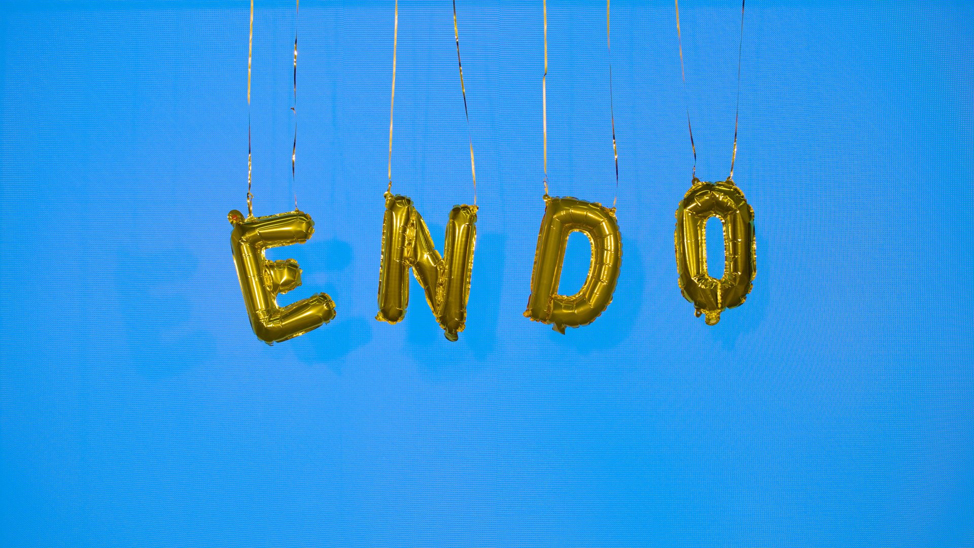 The word 'endo' is spelled out in gold balloons hanging down. Behind is a blue background.