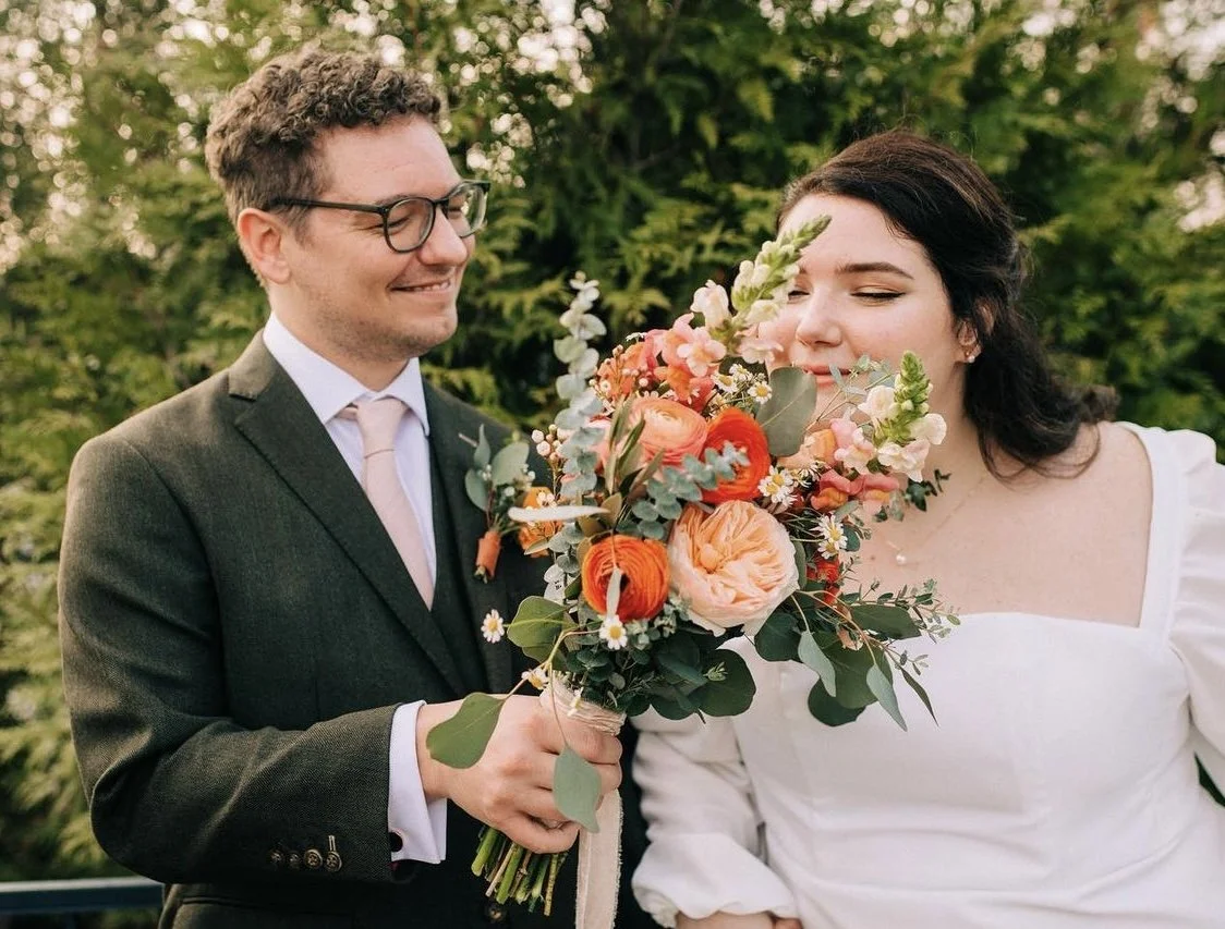 Bride with professional hair and makeup smelling her flowers