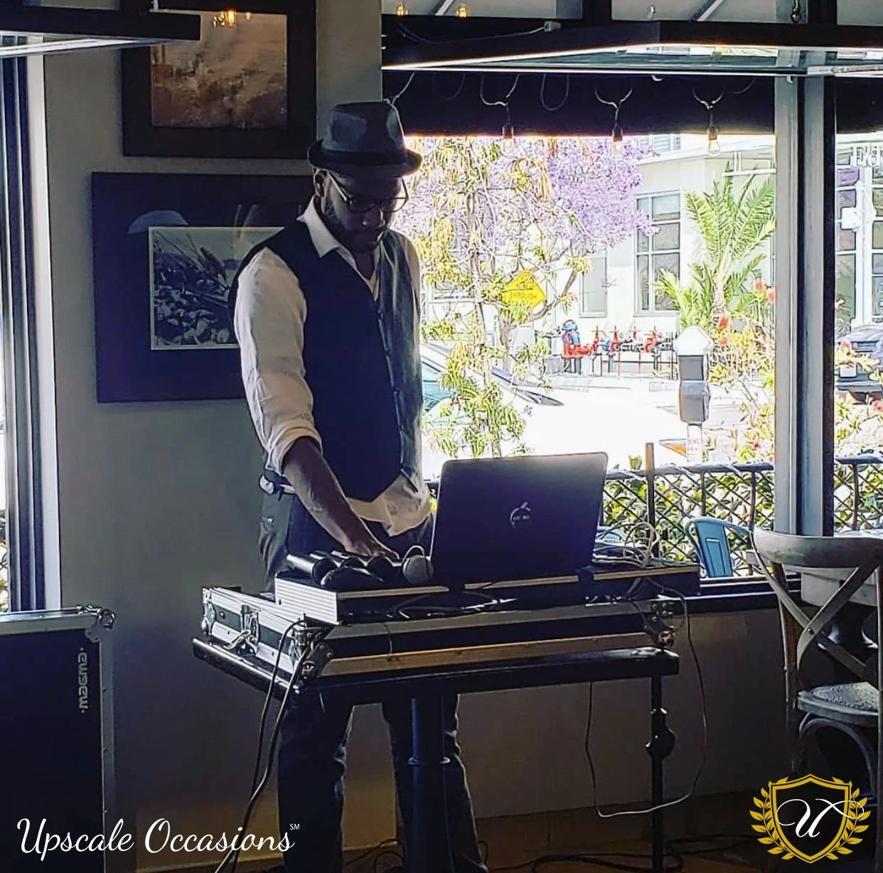 DJ in a vest works a show with microphones.