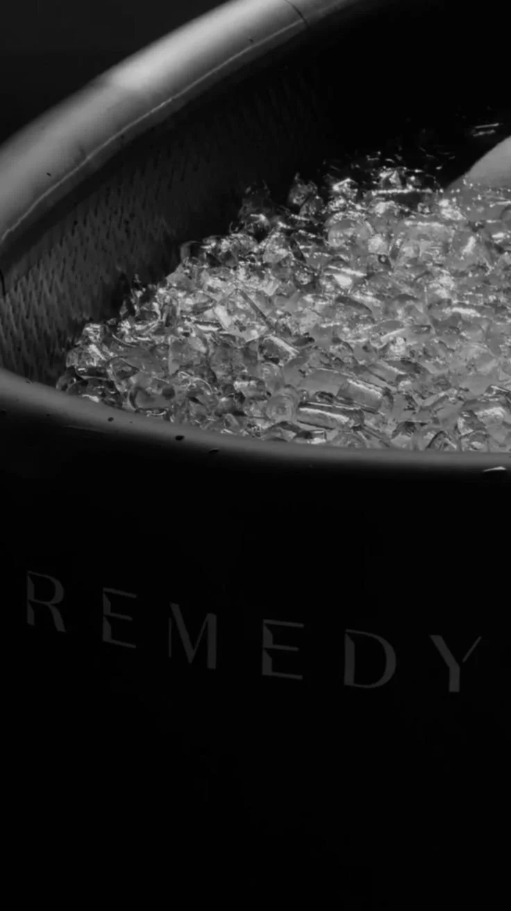 A woman in orange workout gear using a resistance band during exercise at a gym.