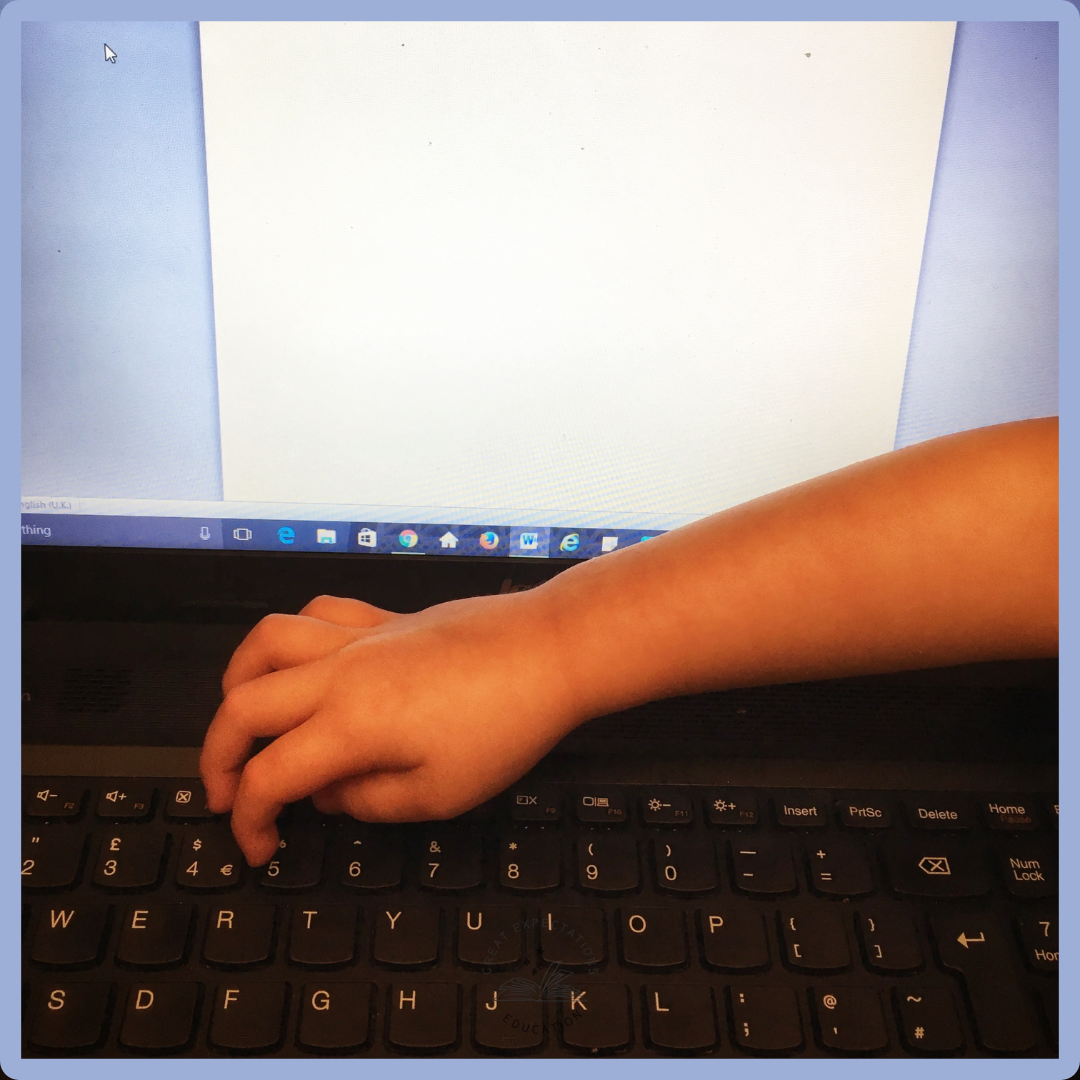 A photo of a computer screen and keyboard with a child's arm resting on the keyboard, touching the keys.