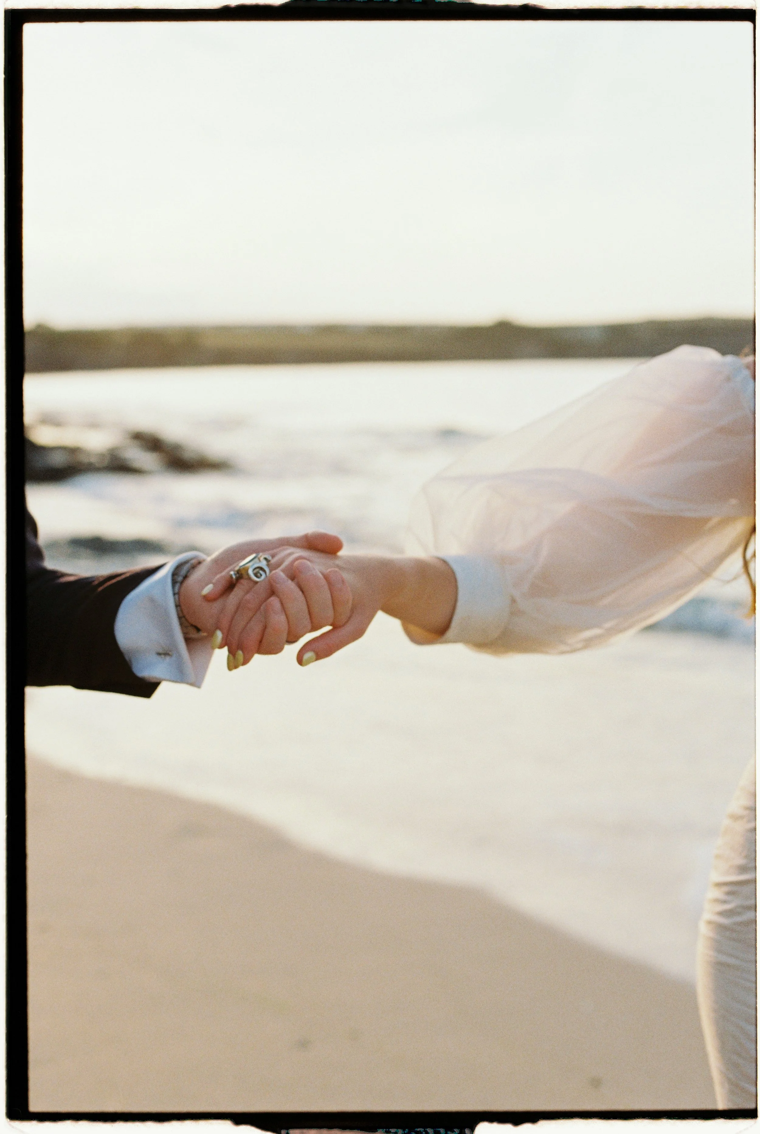 dreamy hazy sunset light coming through the sleeves on the brides vintage wedding dress at harlyn bay