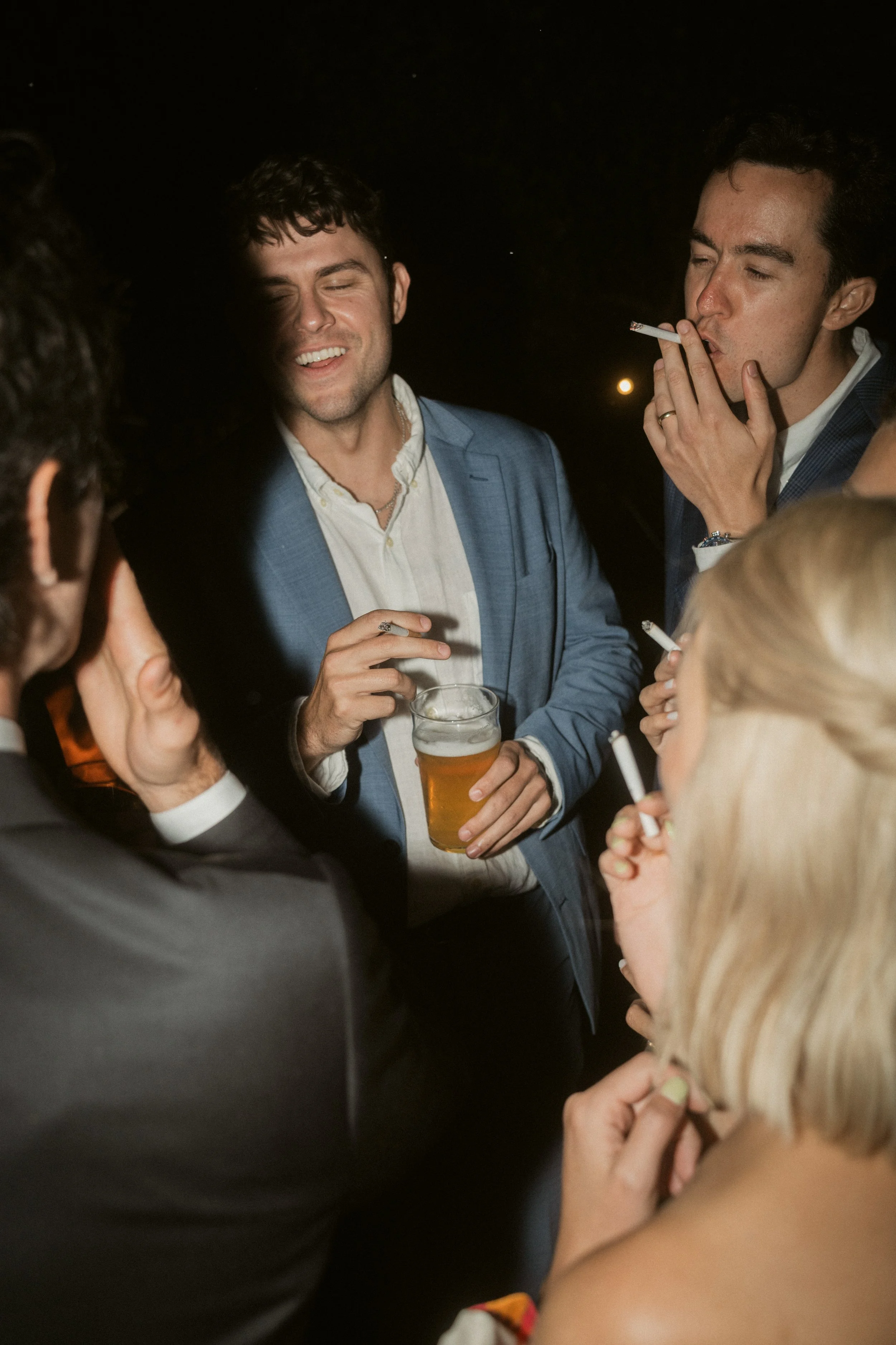 evening candid moments of everyone standing around smoking cigarettes