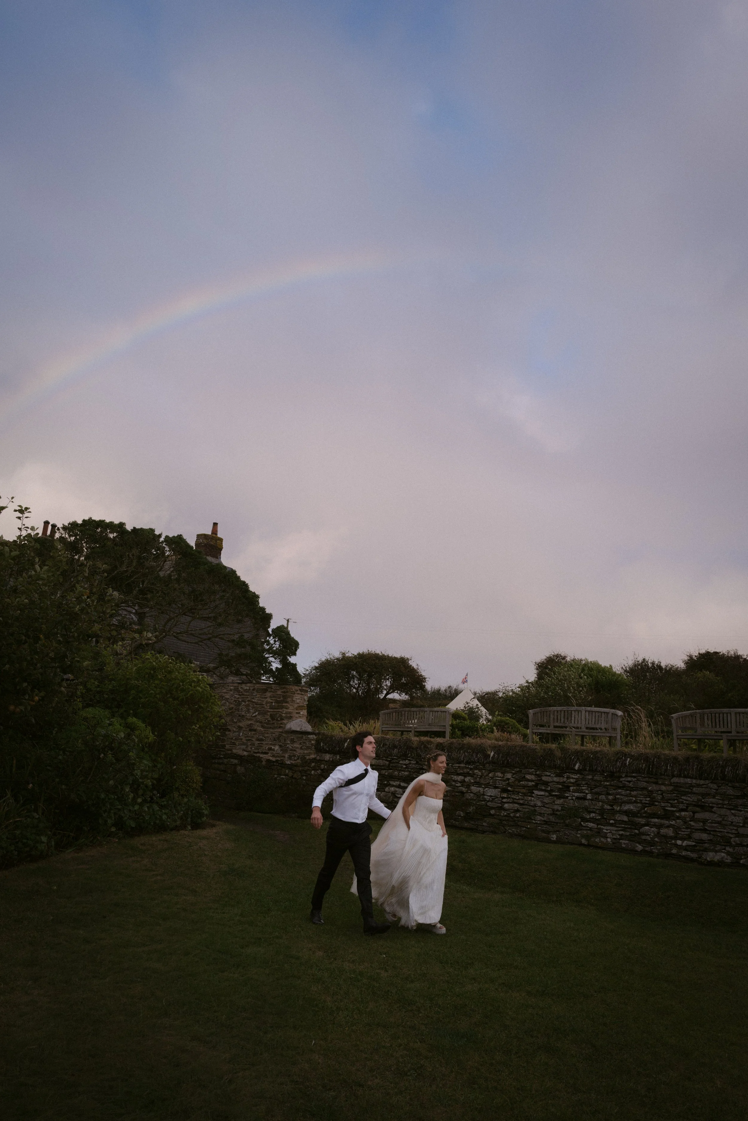A rainbow appears at a rainy summer wedding at Roscarrock