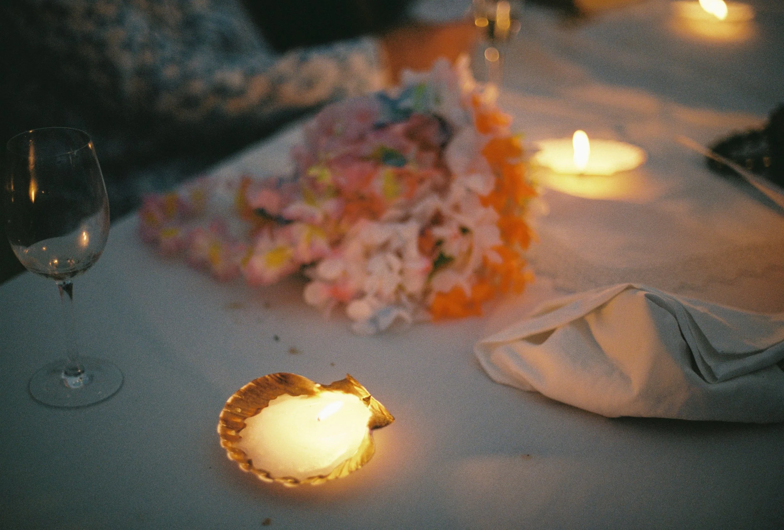 dusky candles and messy table scapes at night capturing the ambience of a seaside wedding