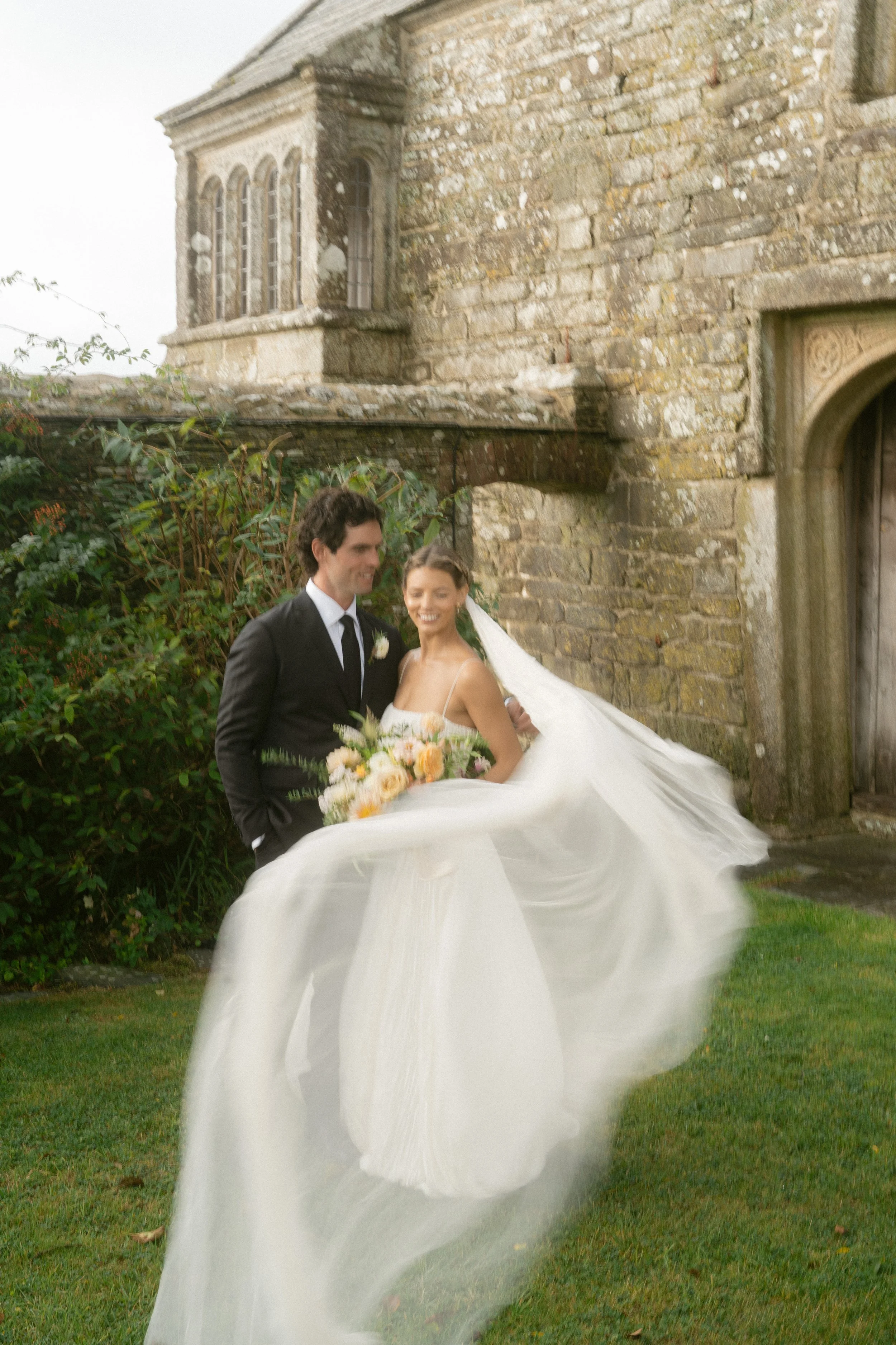 stylish roscarrock wedding captured in whimsical style with motion blur and bride wearing danielle frankel studio