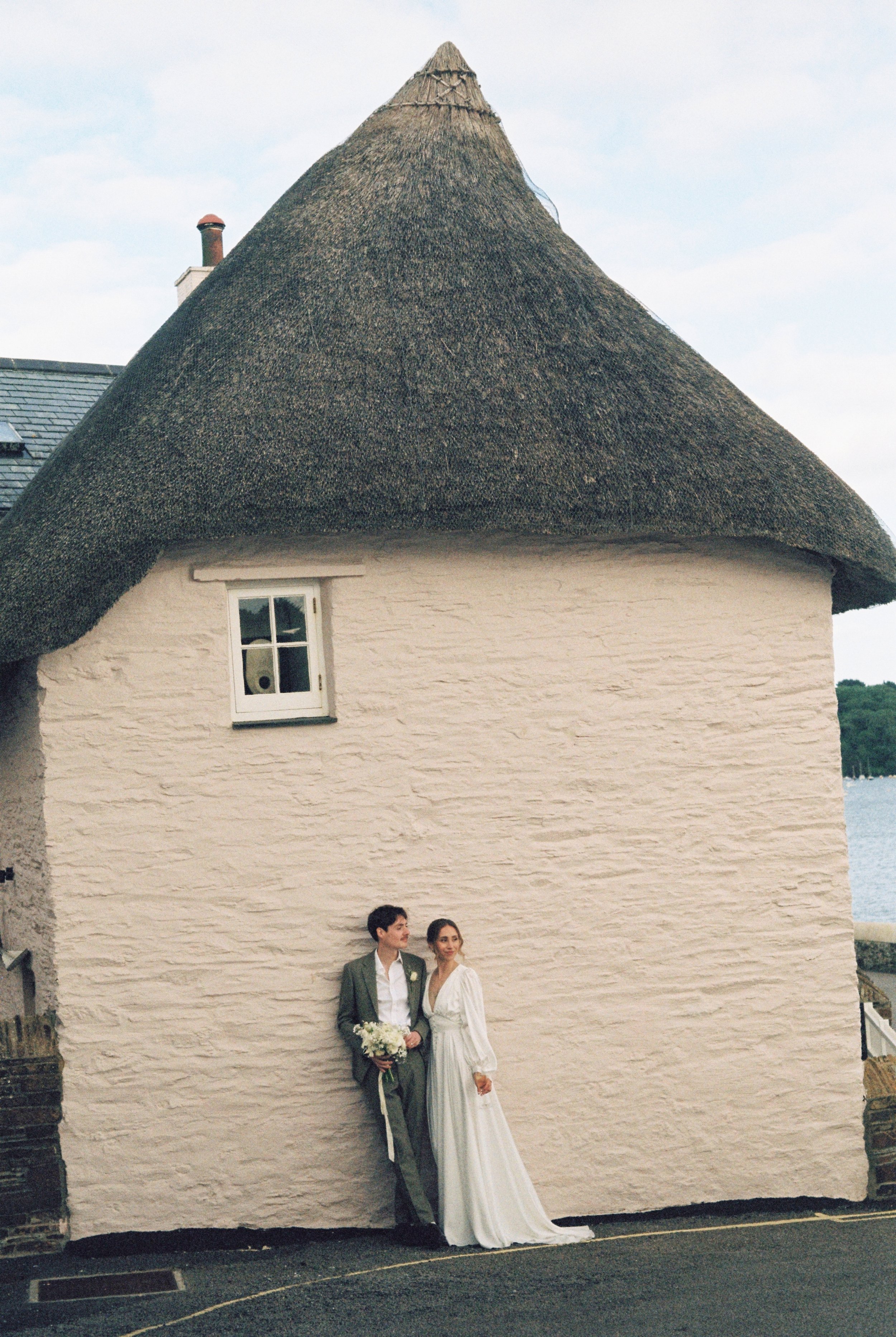 cute thatched cottages in cornwall with pink backdrop for elopement photos by the sea