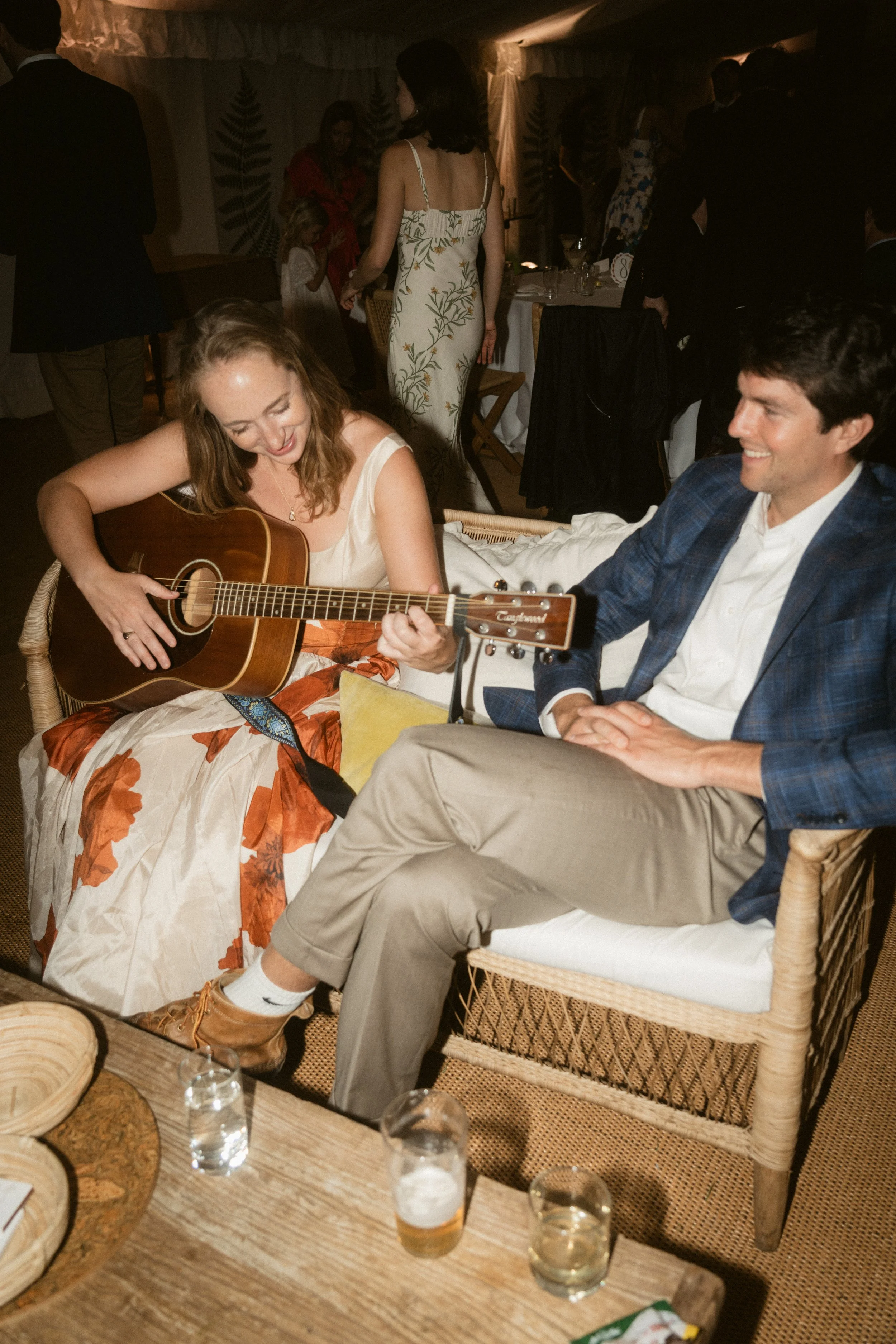 a couple playing the guitar and jamming during the evening reception at a summer cornwall marquee wedding captured by southwest luxury wedding photographers and videographers