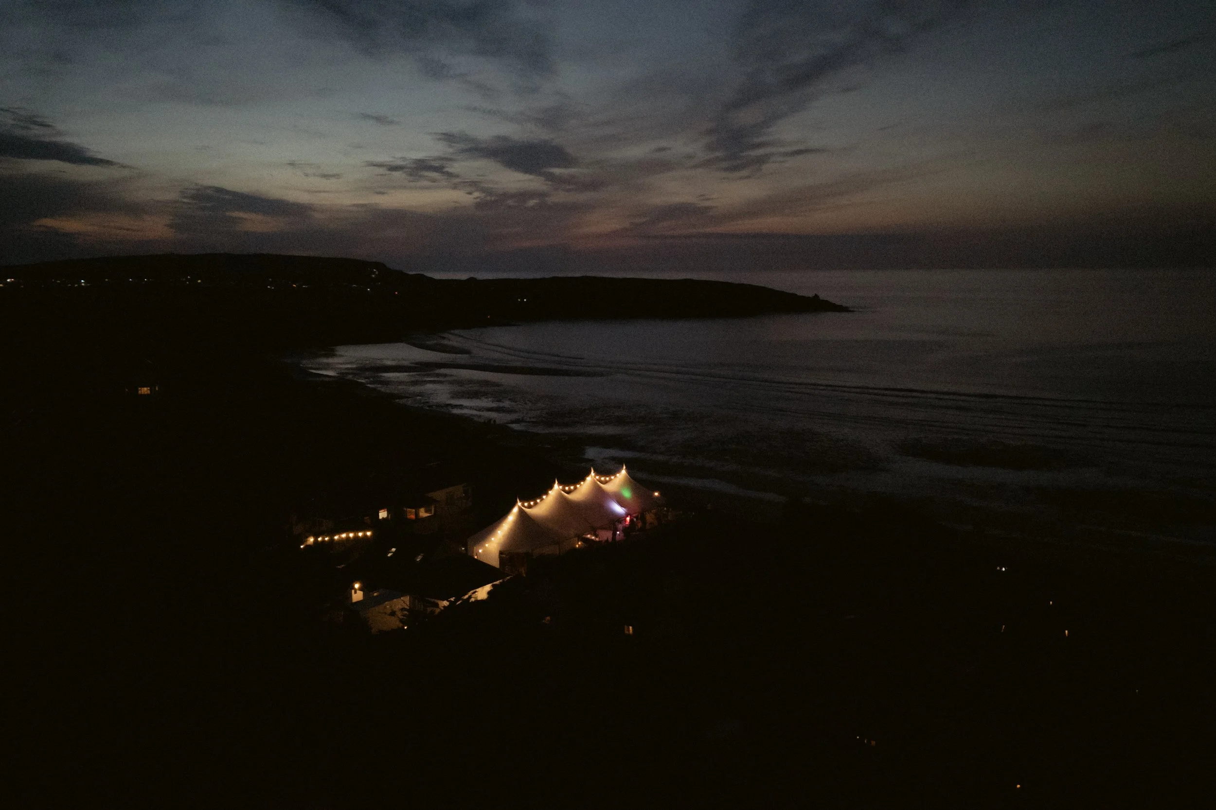 evening dusky drone shots of a marquee for a cornish seaside wedding