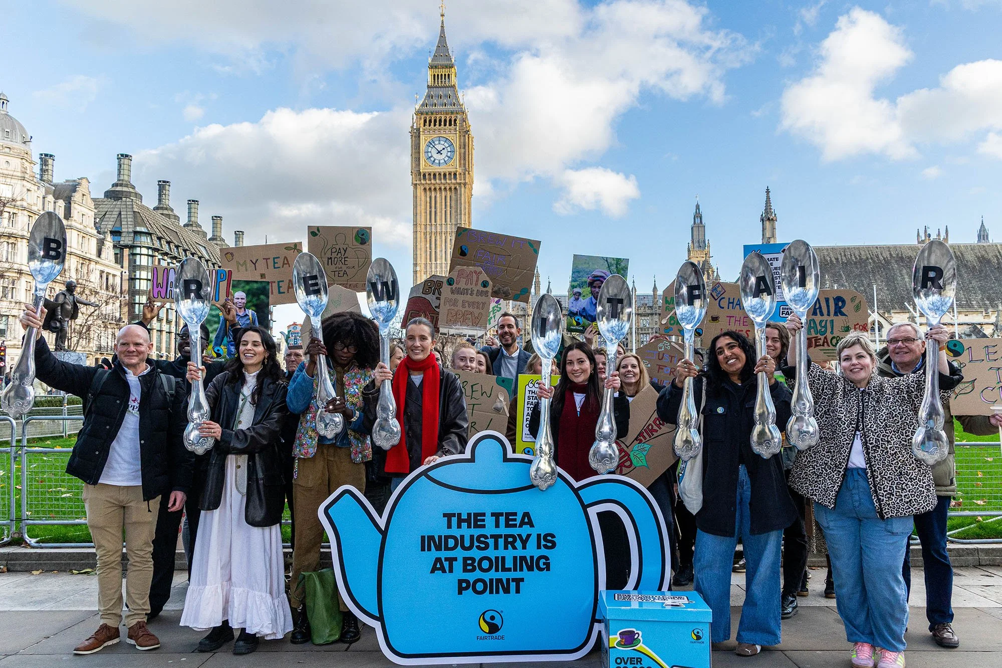 Petitioners standing in front of Big Ben holding big silver teaspoons