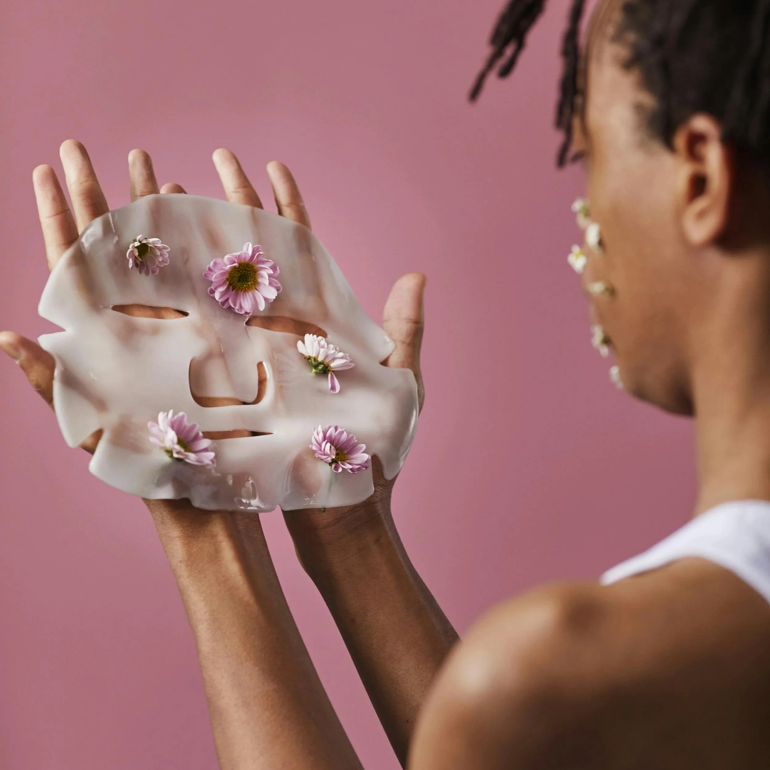 A man looks wonderingly at the face mask in his hands.