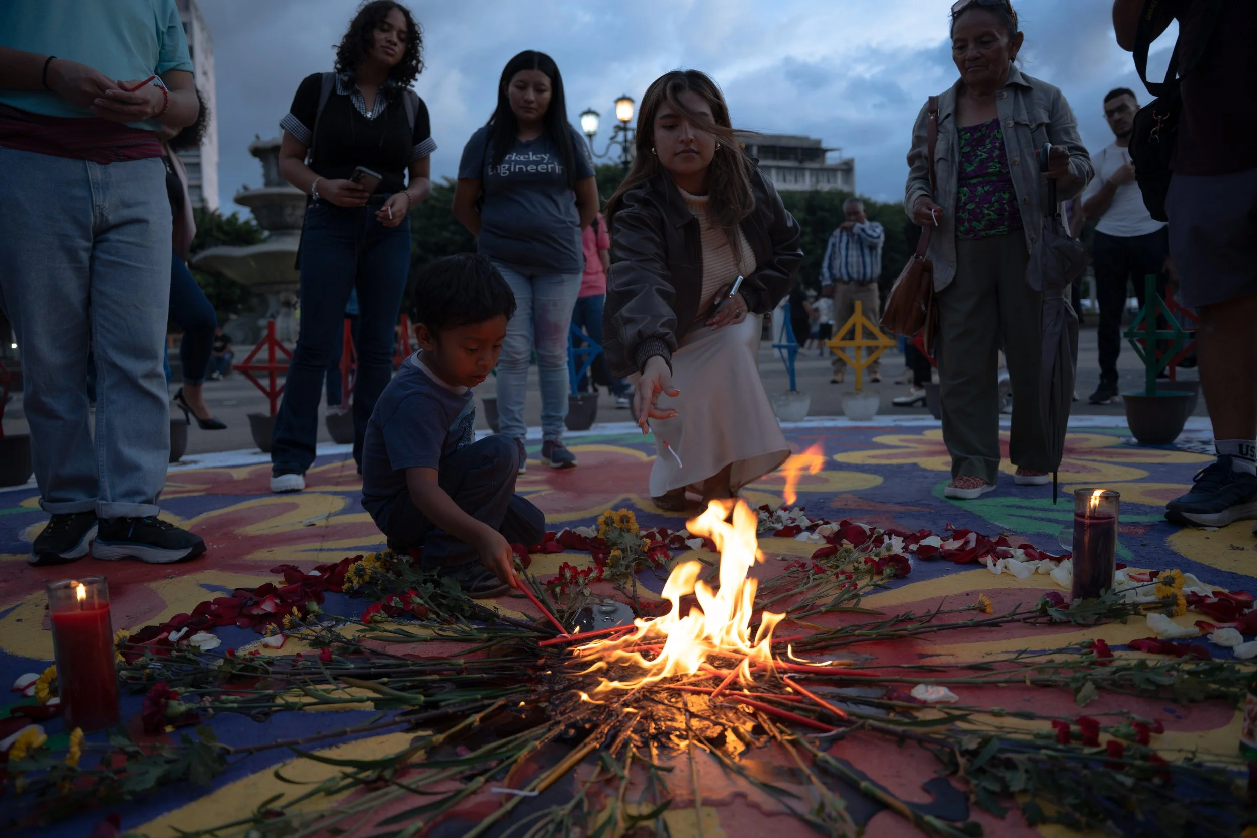 After the sentencing, the sun set on families and supporters gathered at the Plaza of the Girls for a memorial. Candles of white, yellow, ruby red, and purple-black wax —the four colors of corn at the heart of Maya cosmovision— were offered into the 