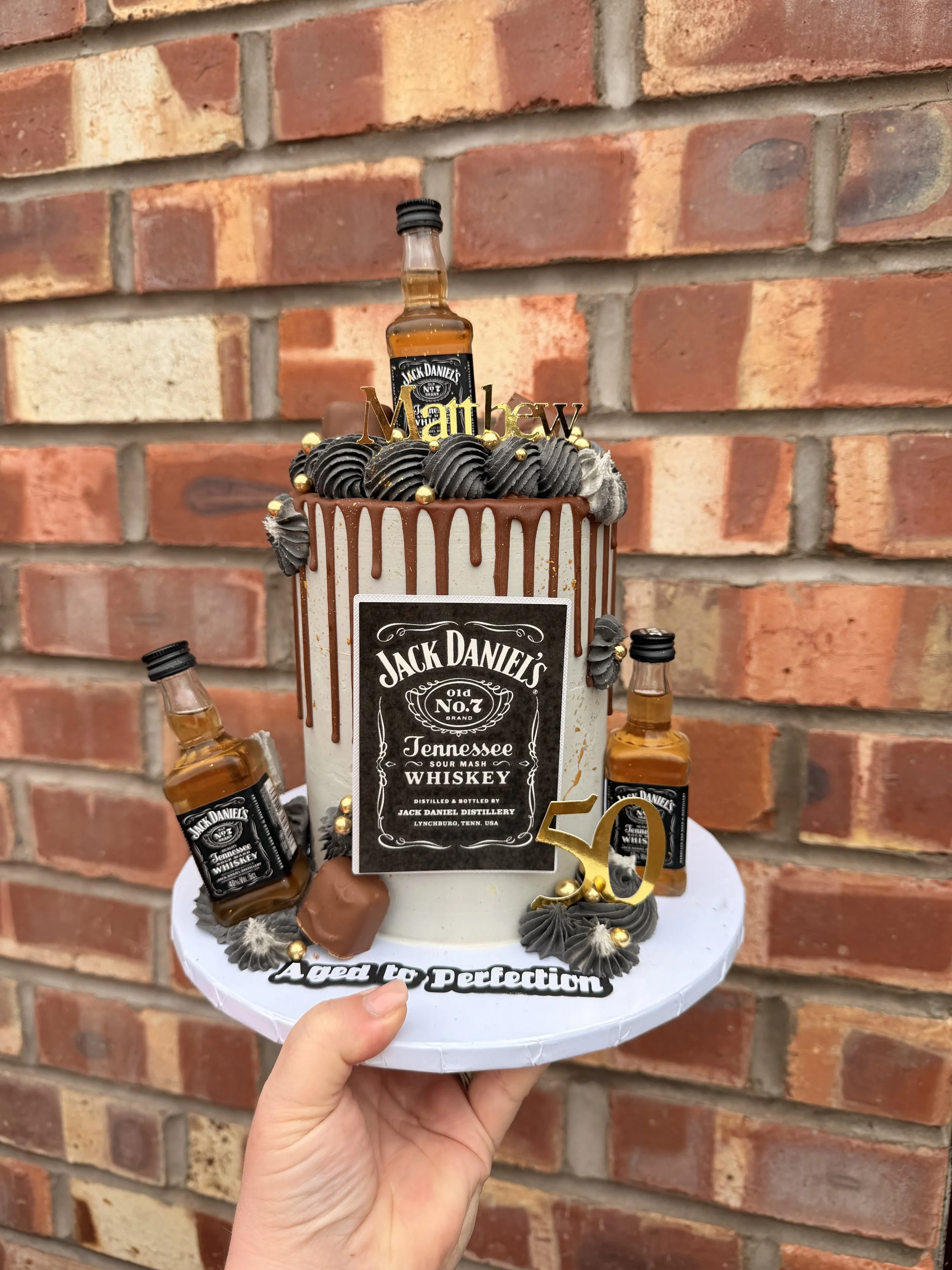 Jack Daniel's themed 50th birthday cake with chocolate drip and personalised decorations