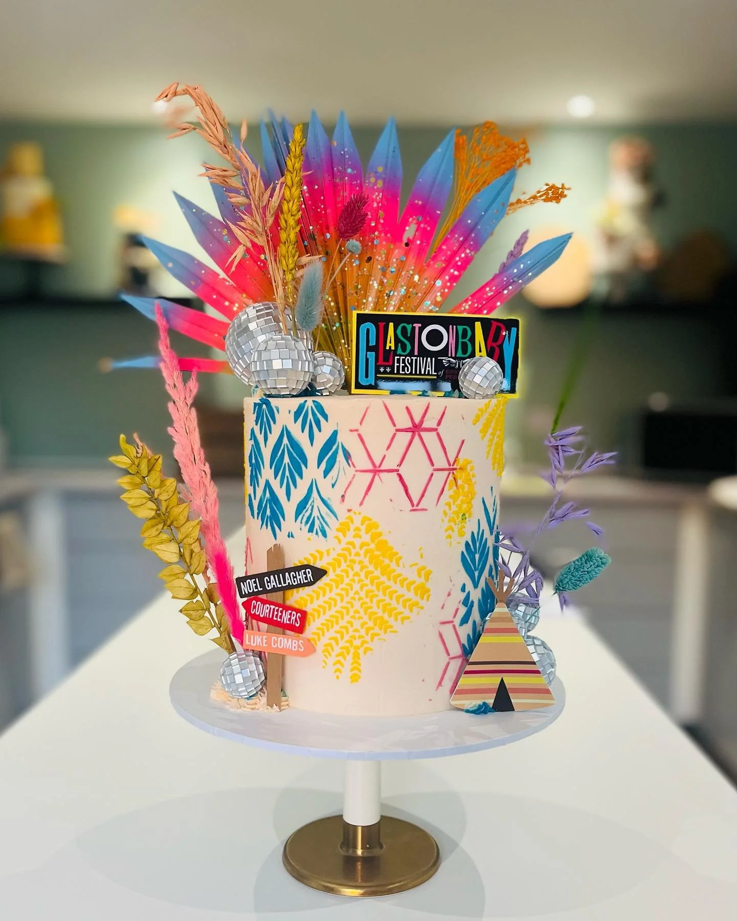 Colourful bespoke Glastonbury themed celebration cake handmade by Merryfall Cakes in Cheshire