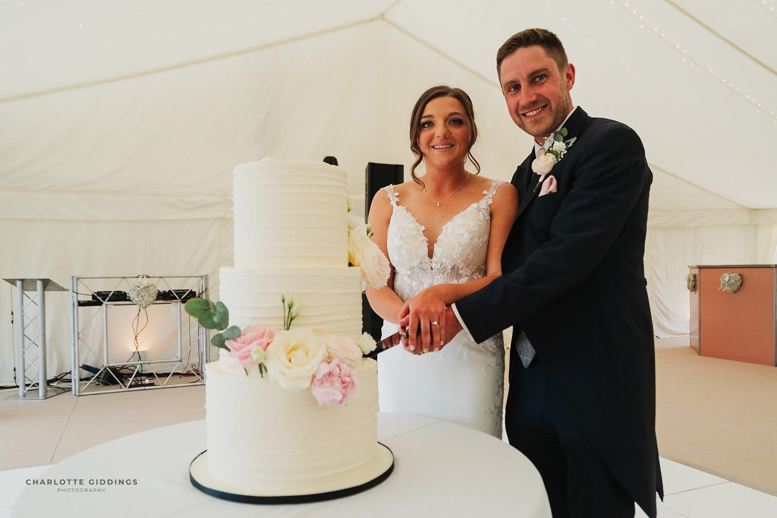 couple cutting a Merryfall cakes wedding cake in a marquee wedding in shropshire