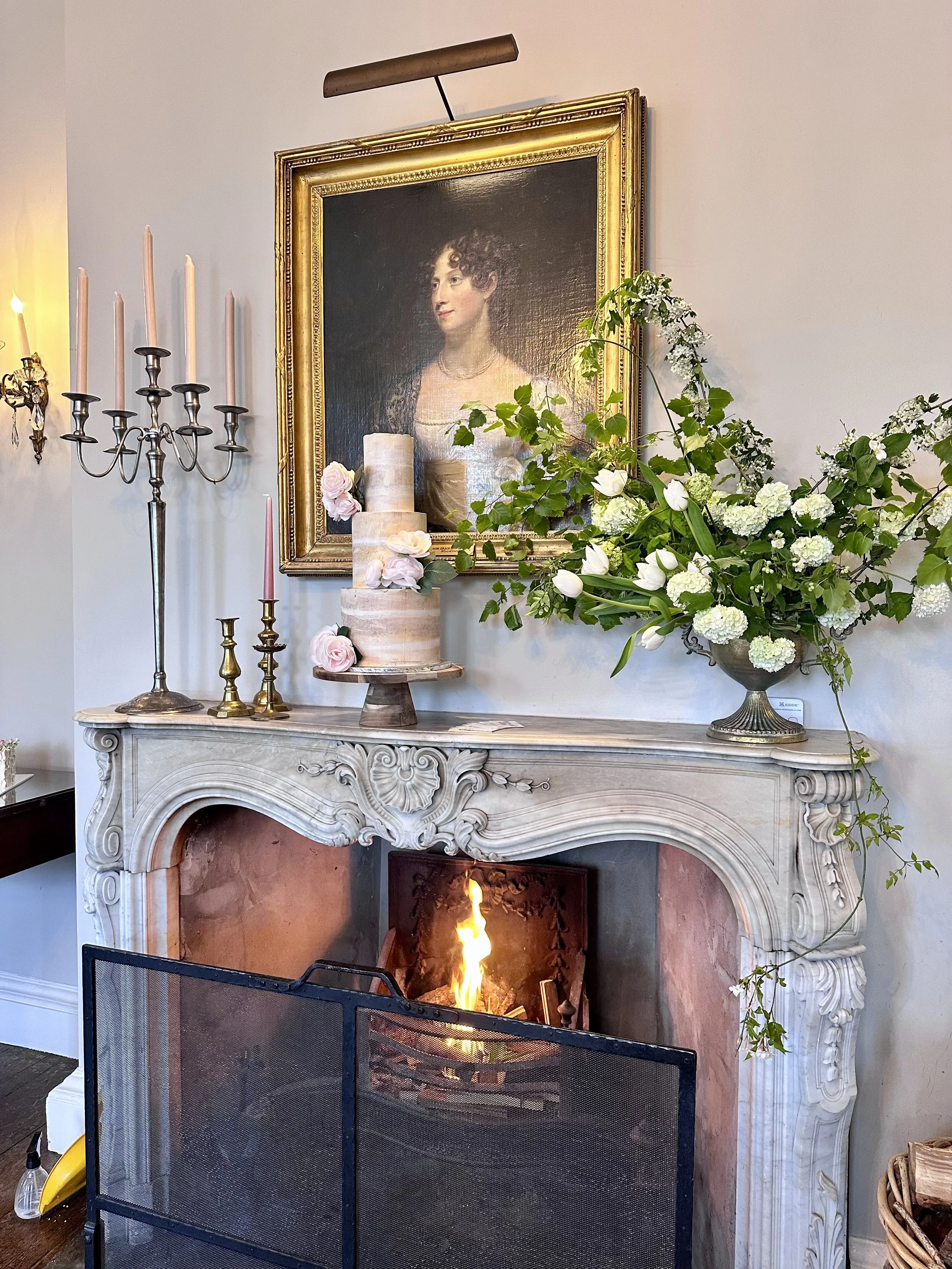 Rustic semi-naked wedding cake above roaring fire in Shropshire