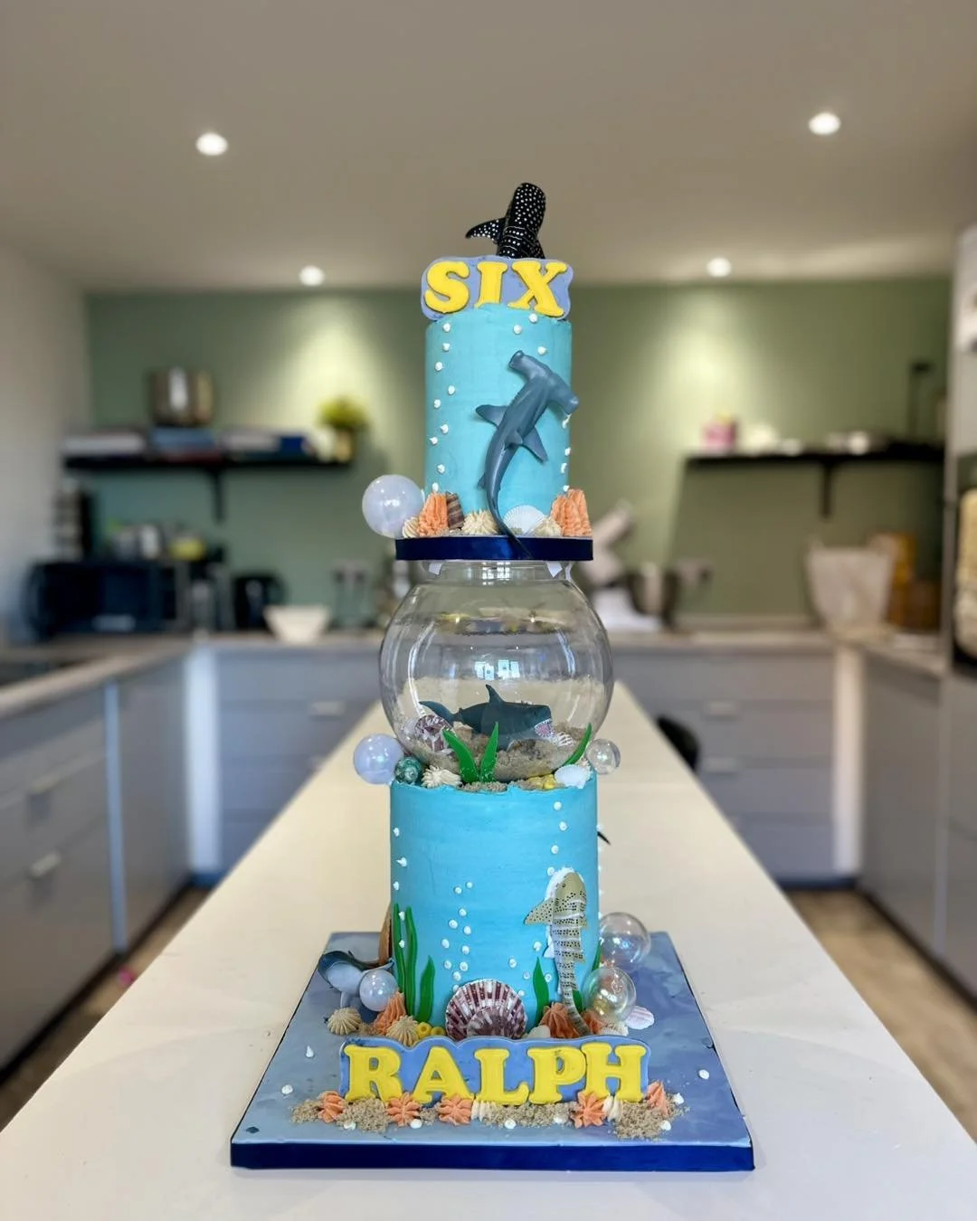 Under the sea themed 6th birthday cake with sharks, fish bowl and ocean decorations