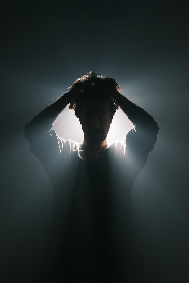 Moody silhouette portrait with backlight, showcasing a sense of mystery and introspection.