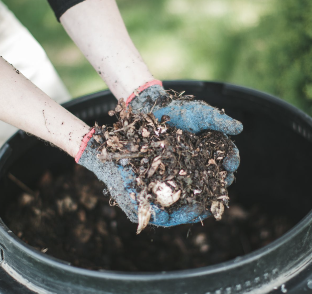 Gloved hands holding compost for amending garden soil