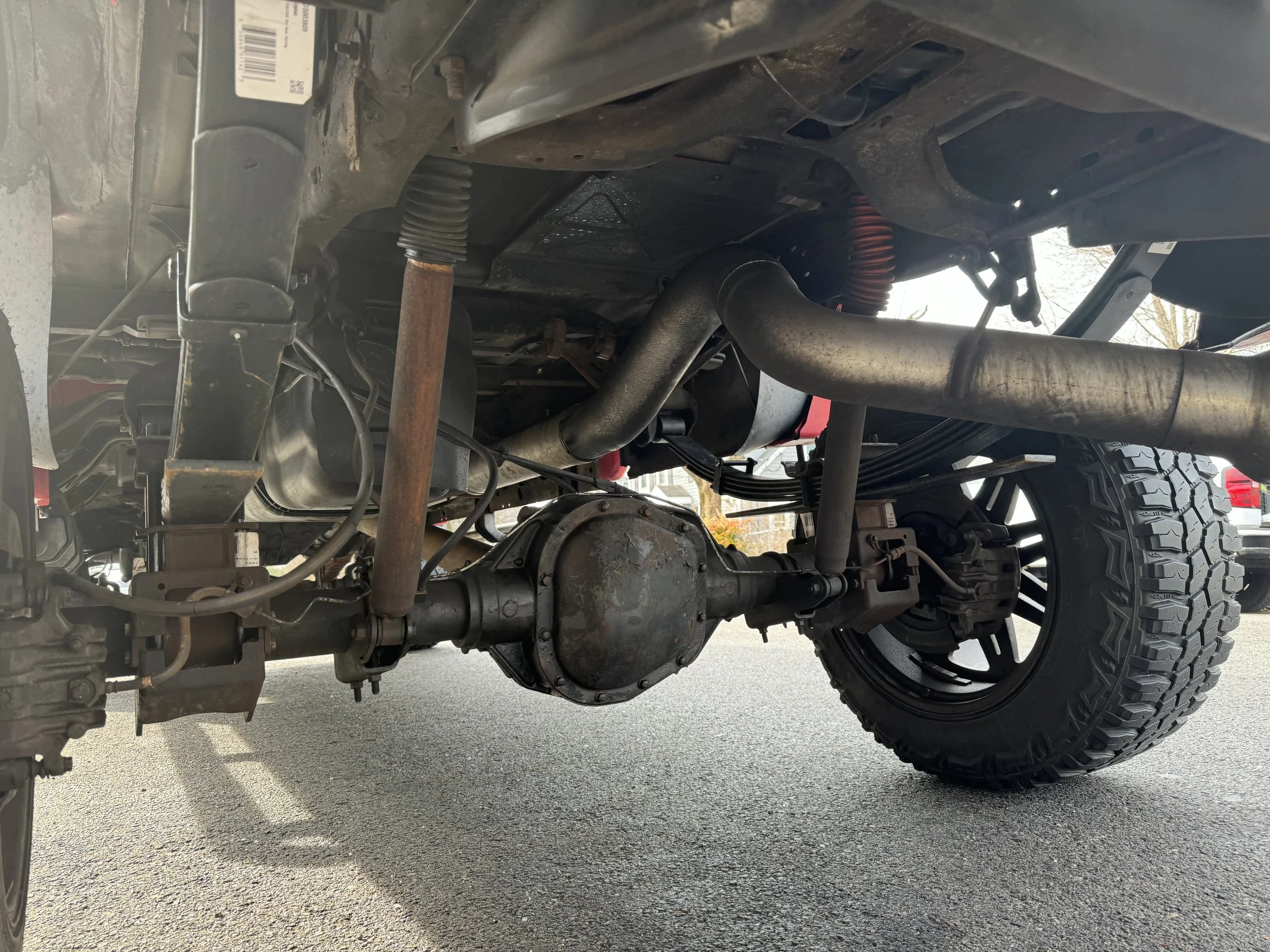 Undercarriage of a vehicle showing suspension, differential, and exhaust pipe.