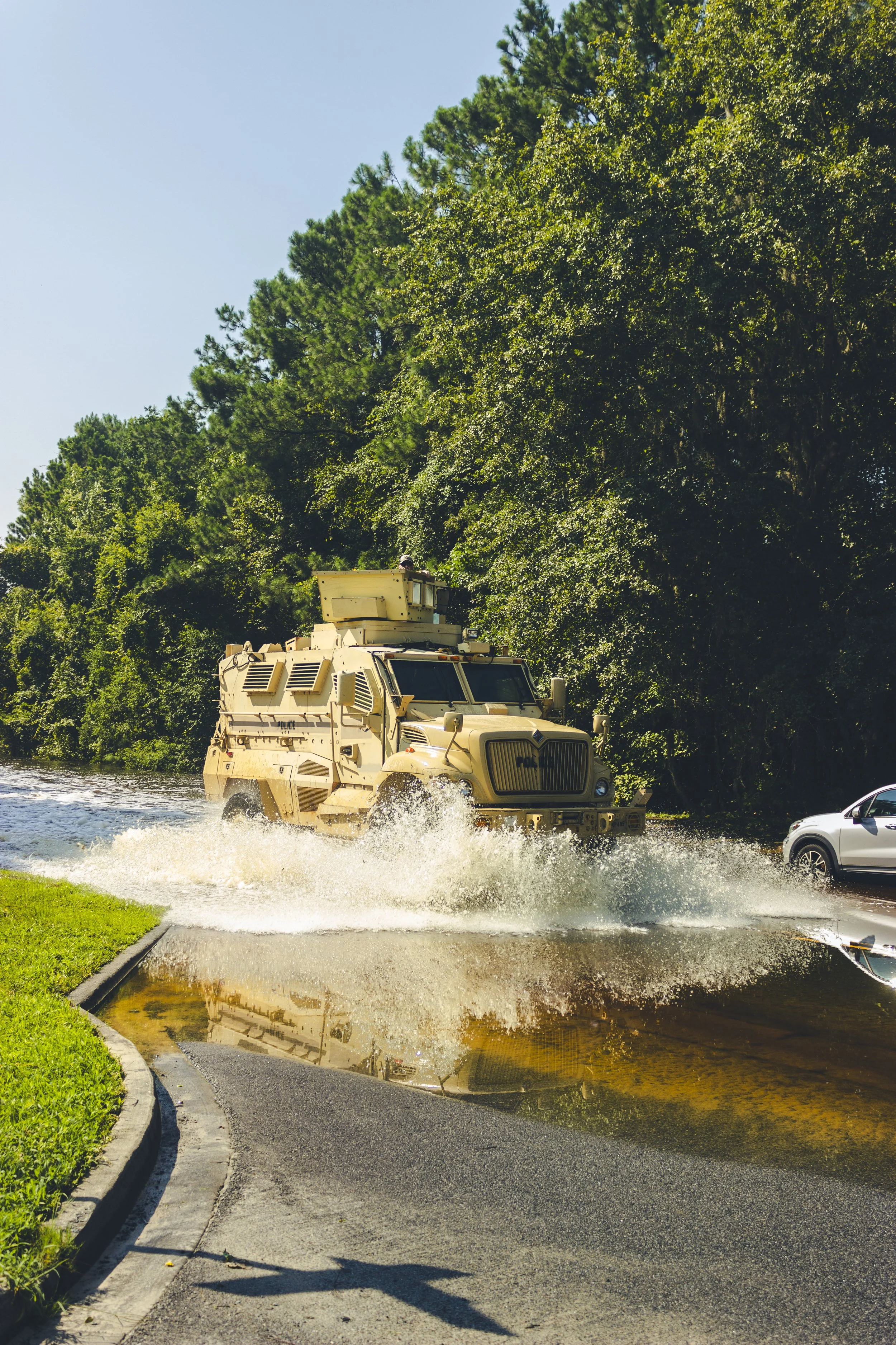 Military-grade police unit plowing through flooded water