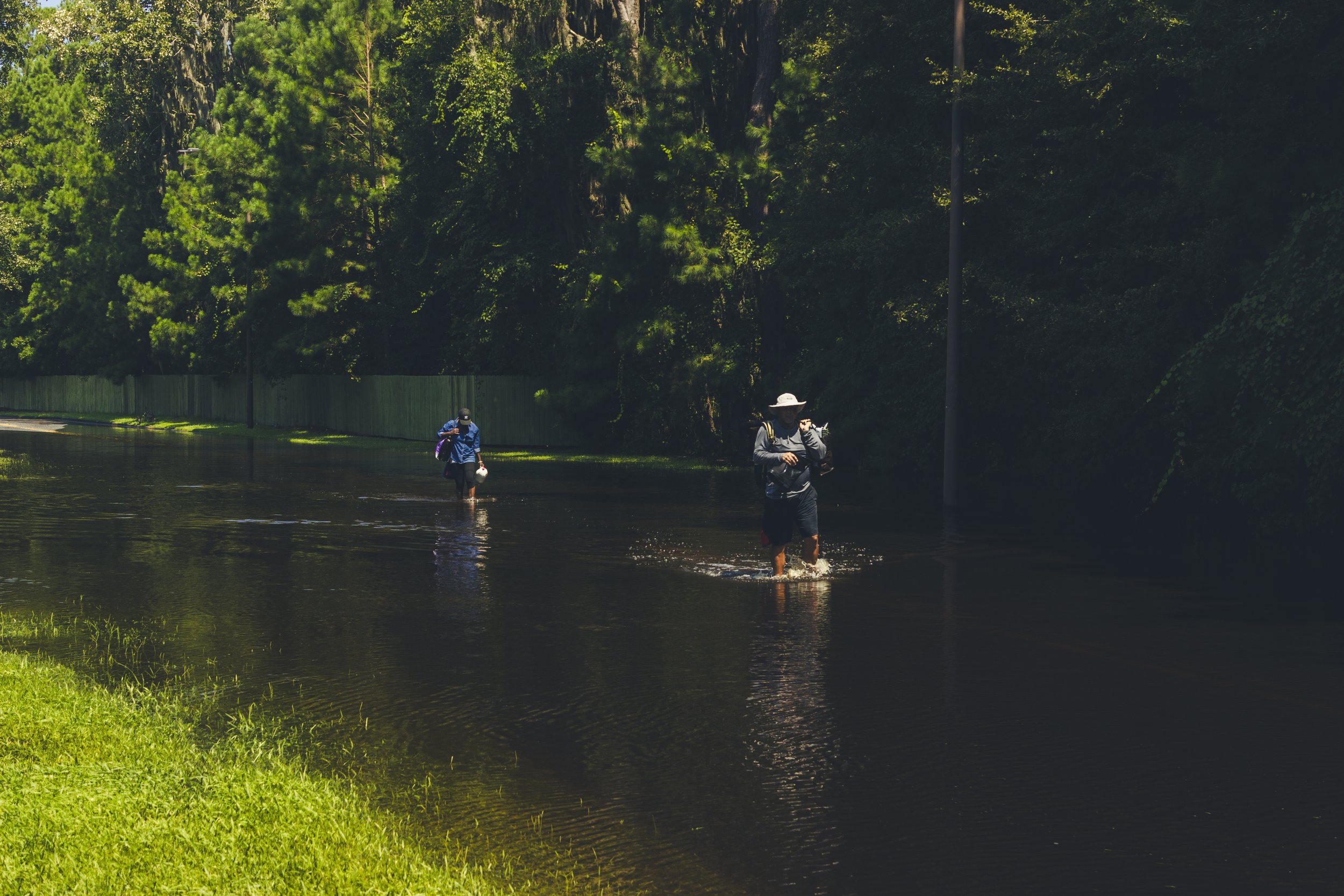 Two residents traversing through the flooded water on Bradley Boulevard