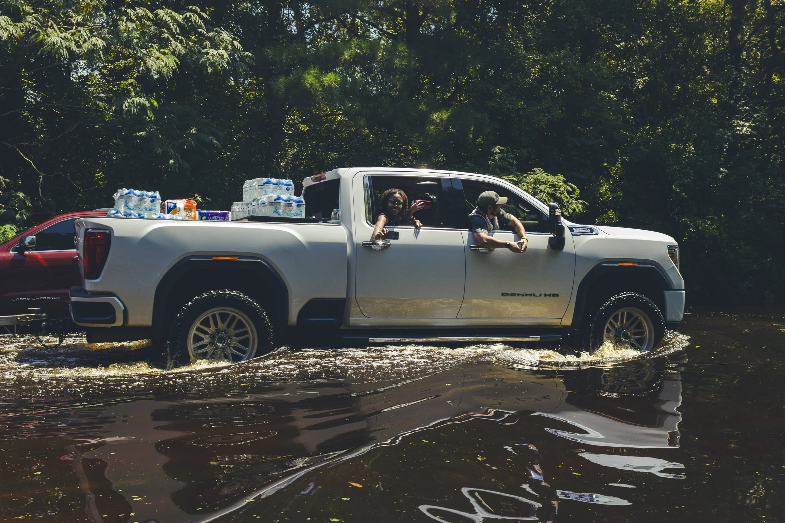 Residents delivering supplies with a truck through the flooded water