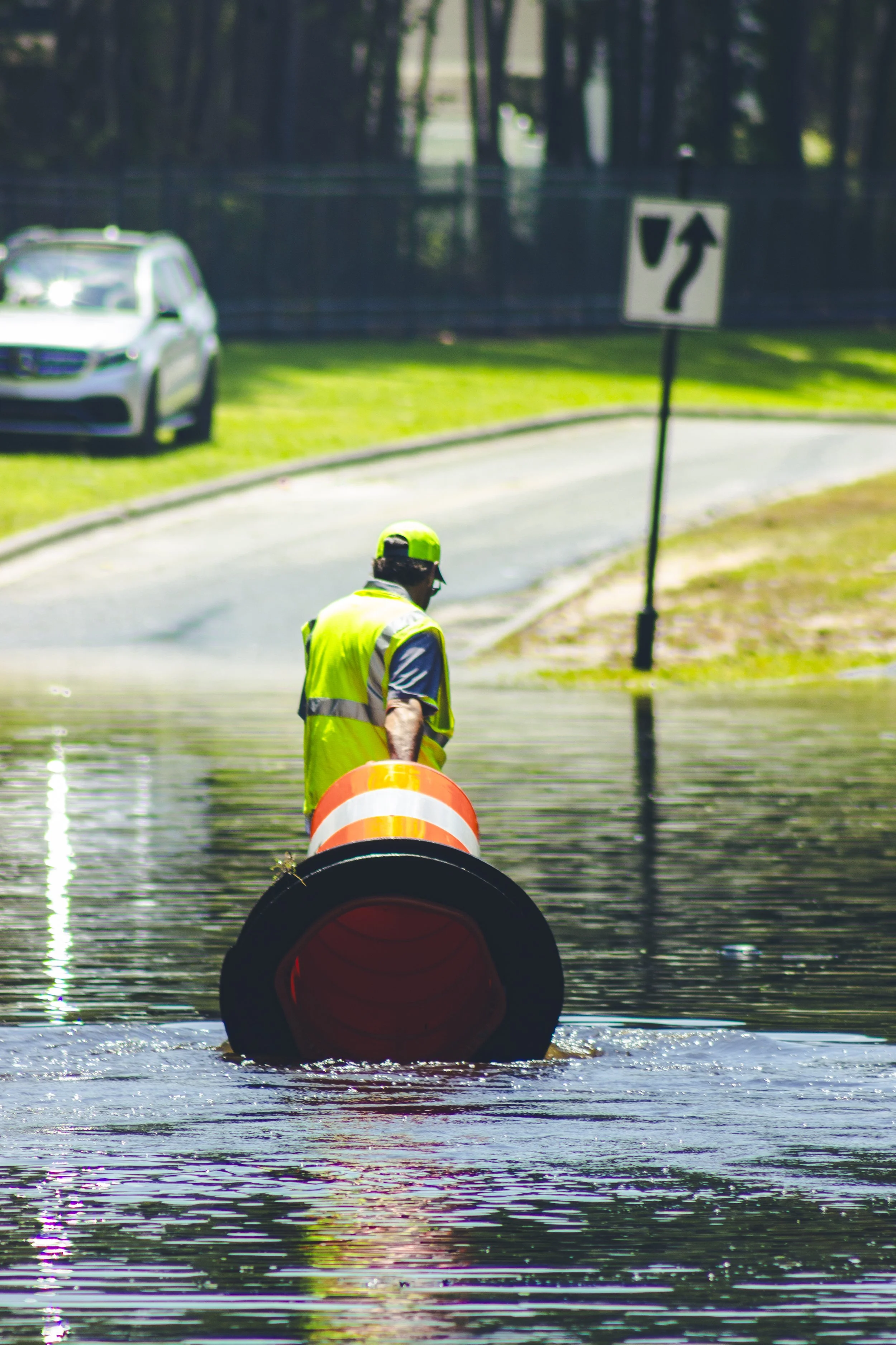 A Savannah city worker dragging traffic cones in the flooded water