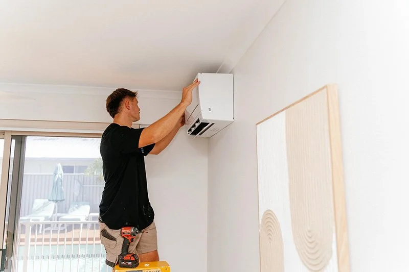 Air conditioning technician repairing split-system air conditioner