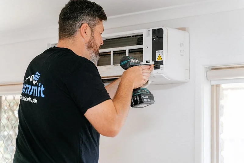 Air conditioning technician repairing split-system air conditioner