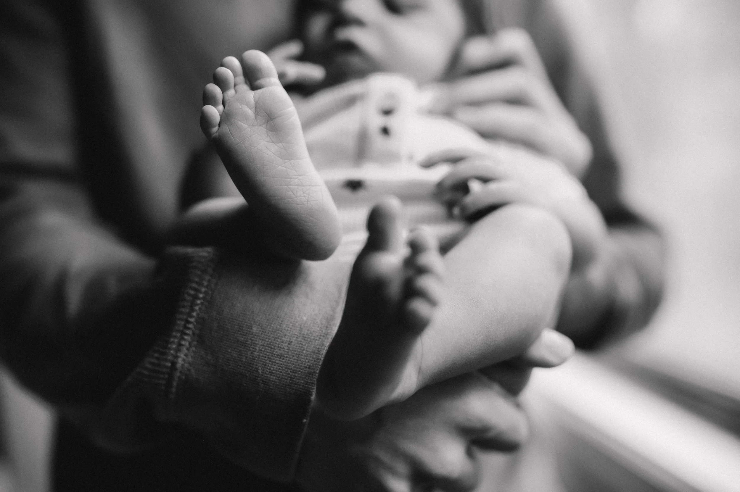 Black and white photograph of a babies feet taken by a photographer during a newborn session in Gainesville, Georgia.