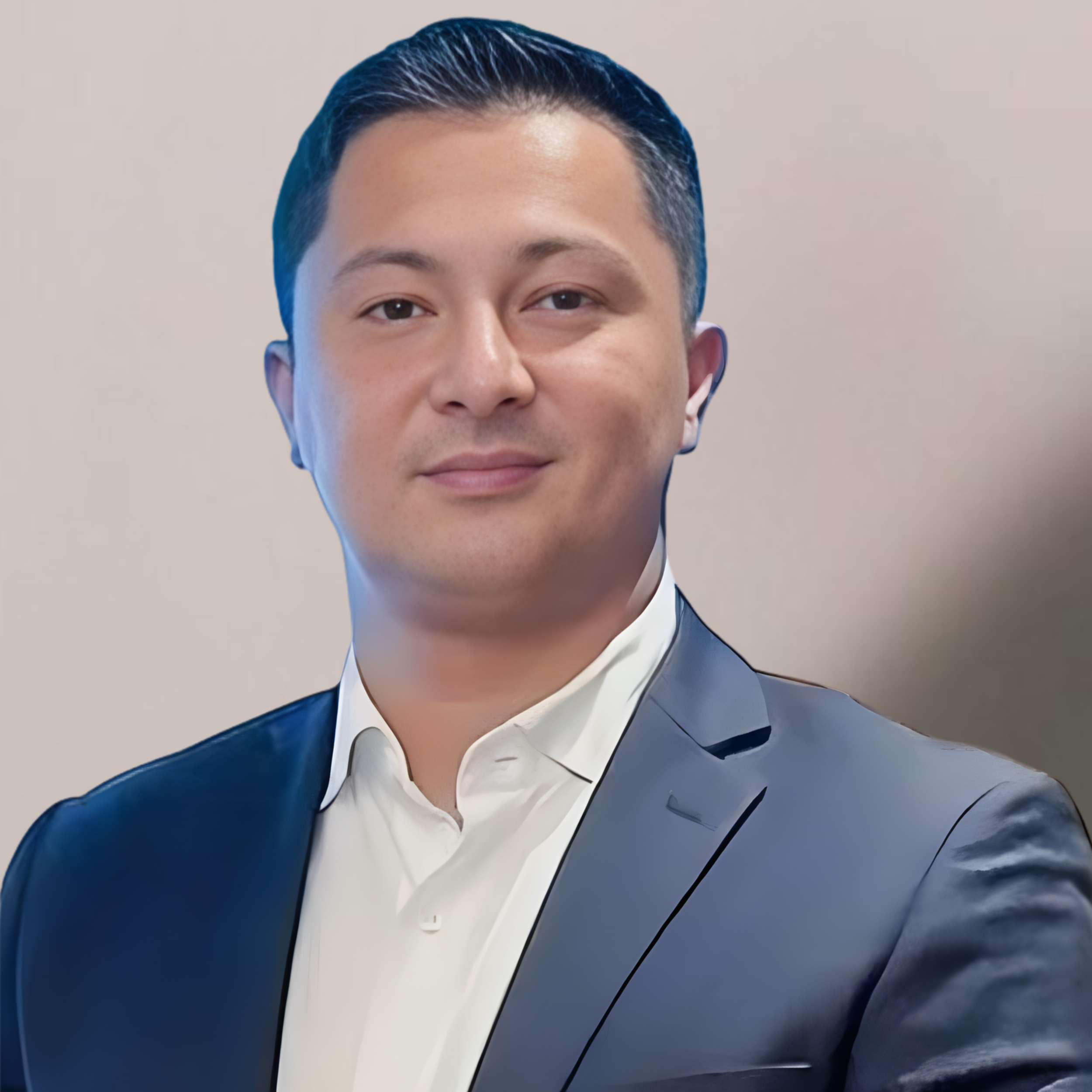 A professional portrait of a man in a suit with a blurred background.