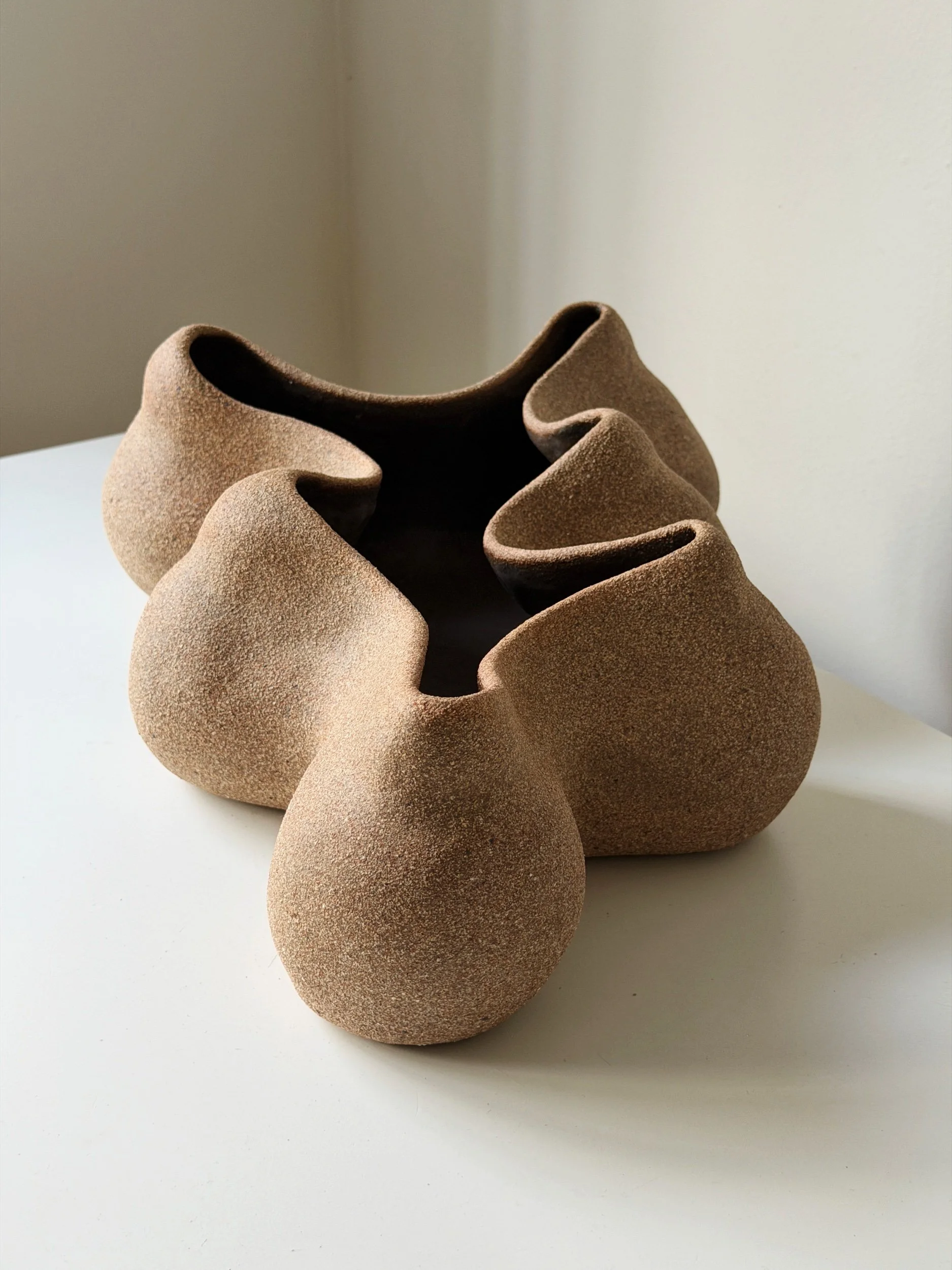 Hand formed pottery vessel. It has organic shape and earthy texture.
